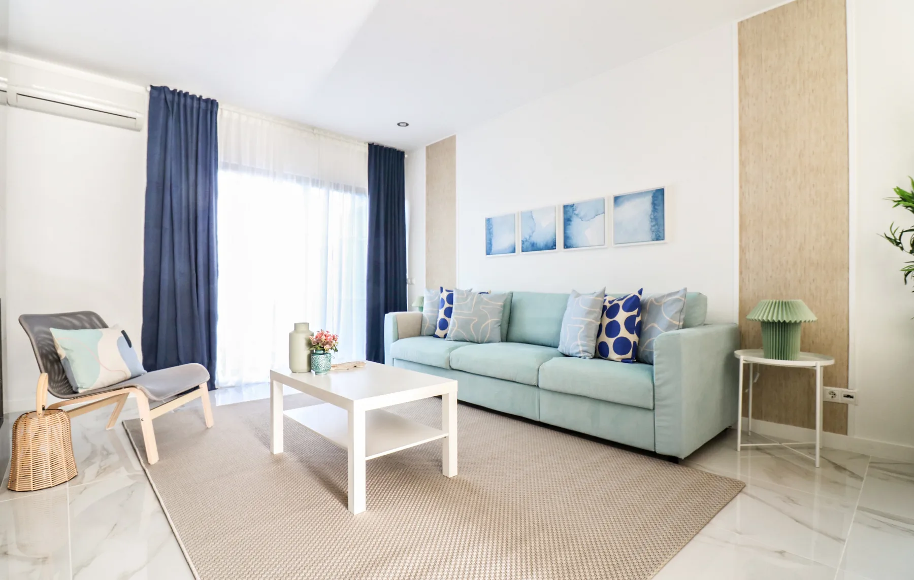 A bright living room with pale seating and a white coffee table.