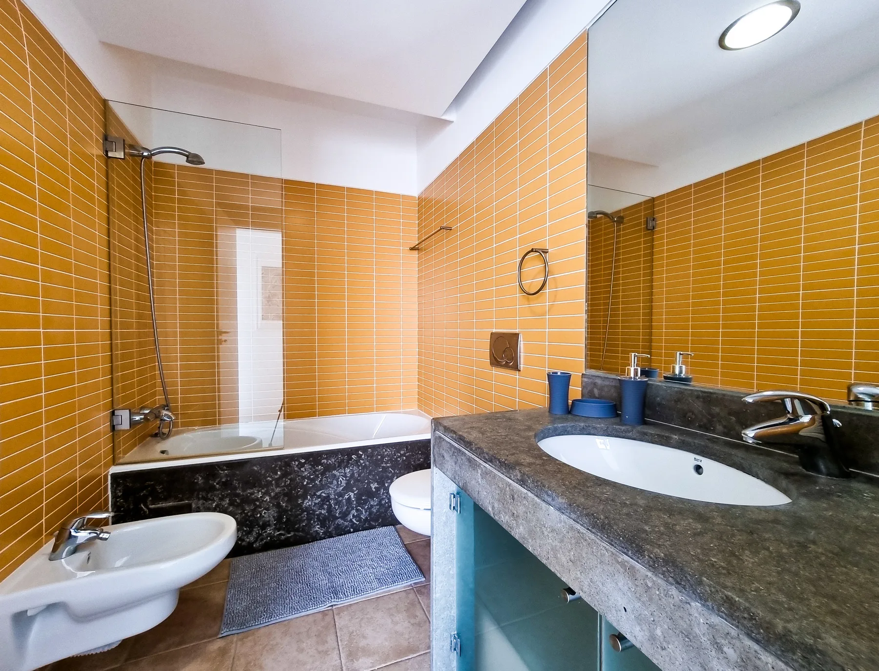 A tiled bathroom with a bathtub, toilet, and sink.