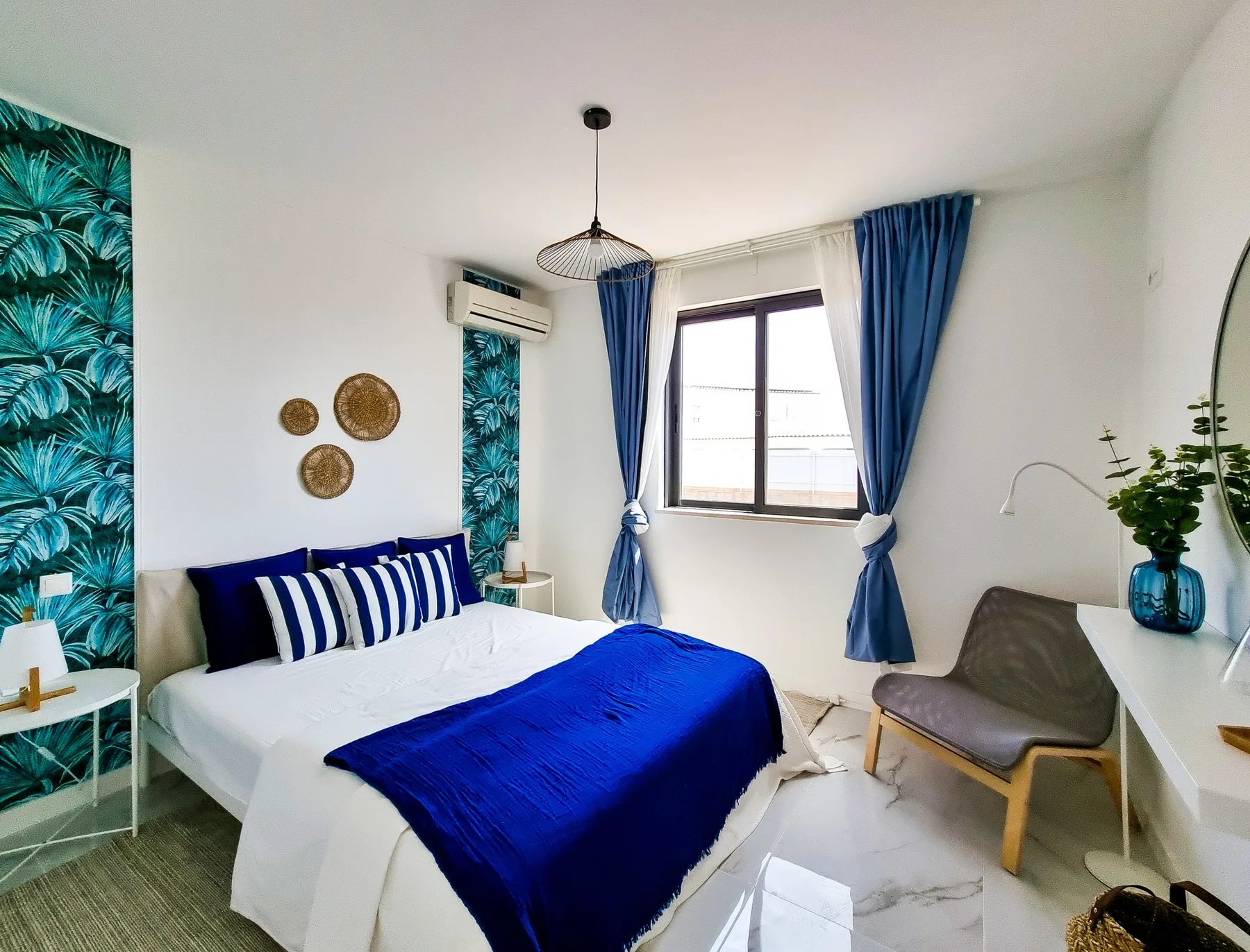 Un dormitorio con una cama, cortinas azules y una ventana.