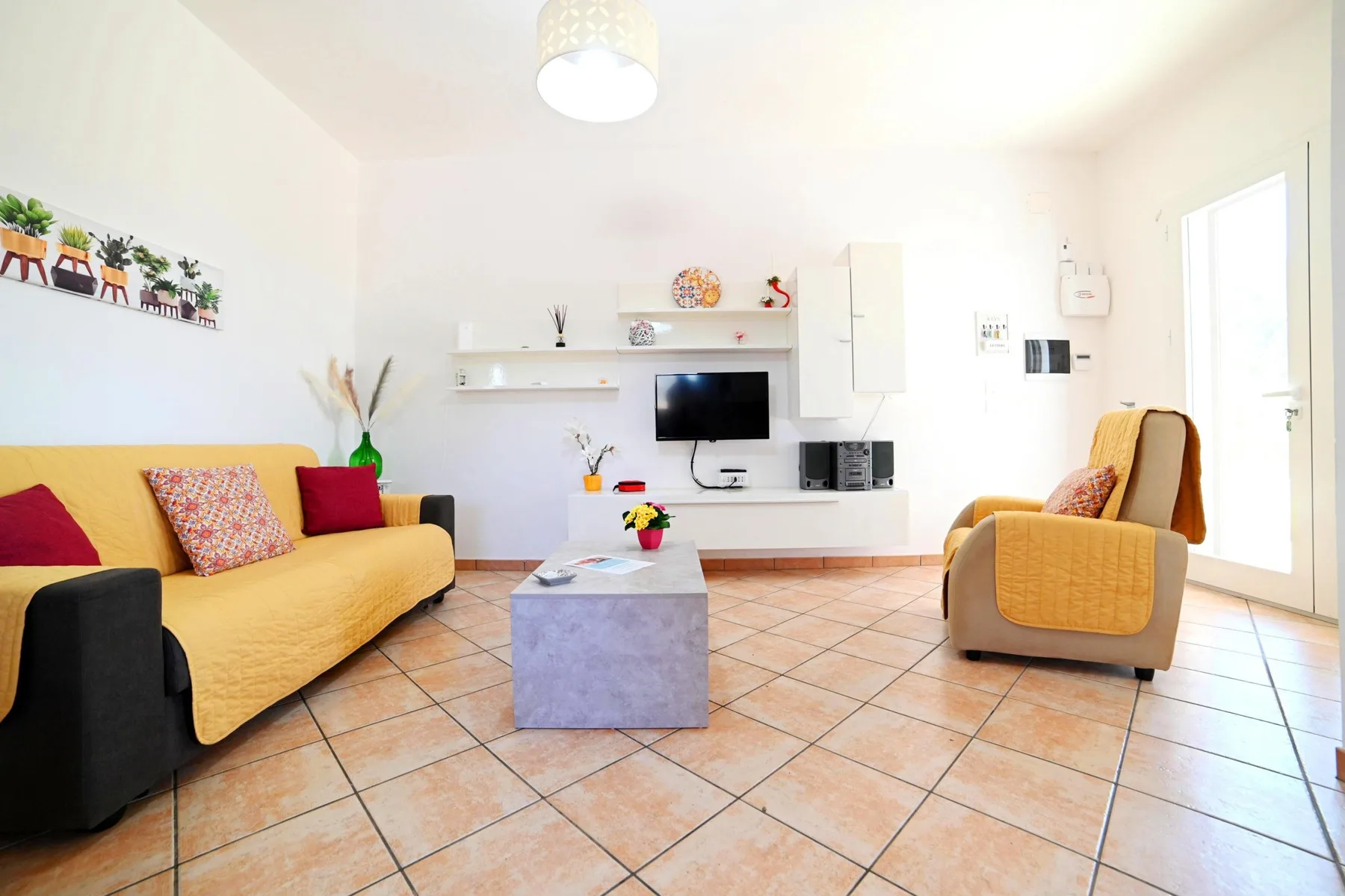 A bright living room with seating around a low coffee table and television.