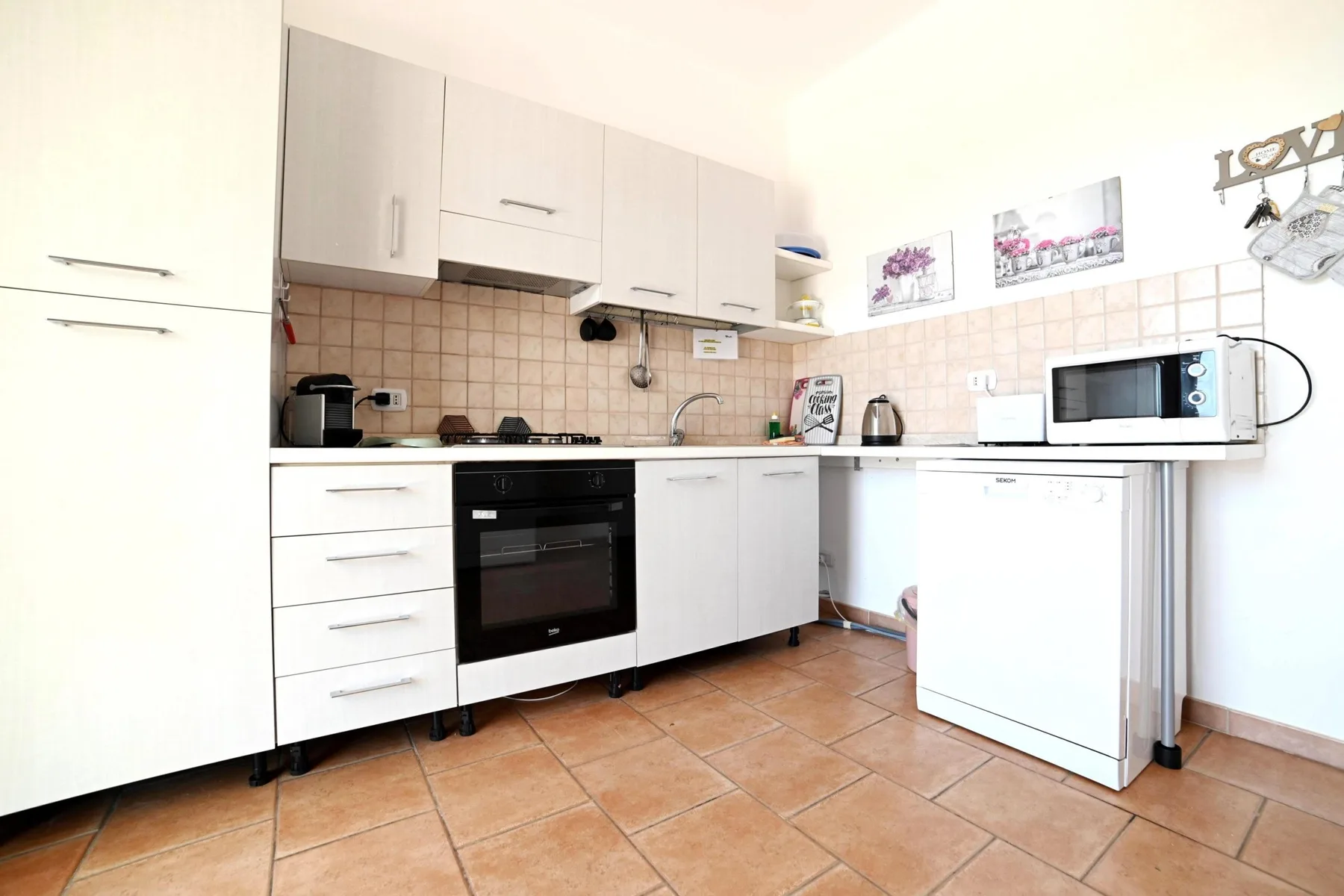 A bright kitchen with white cabinets, a countertop, and an oven.