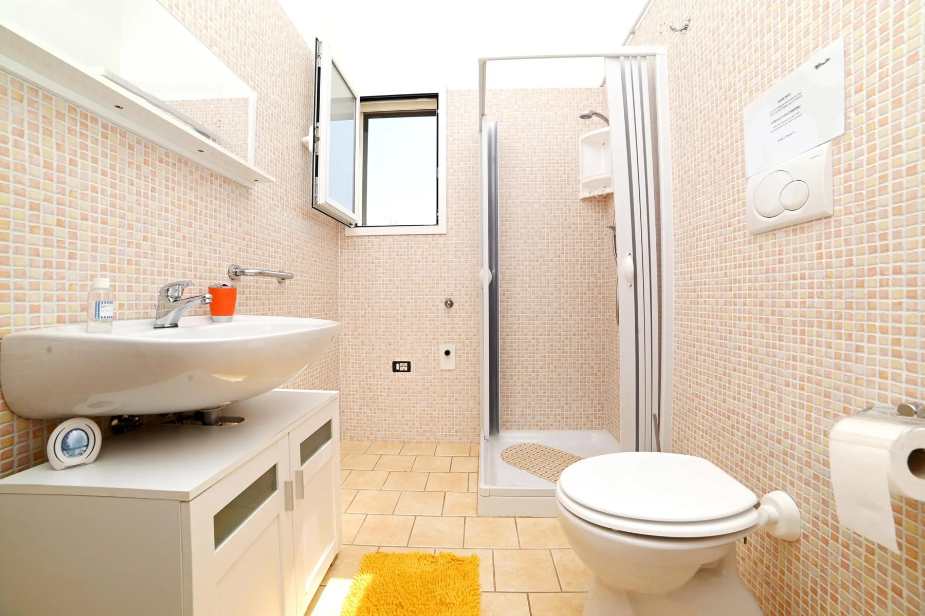 A tiled bathroom with a sink, toilet, and shower.