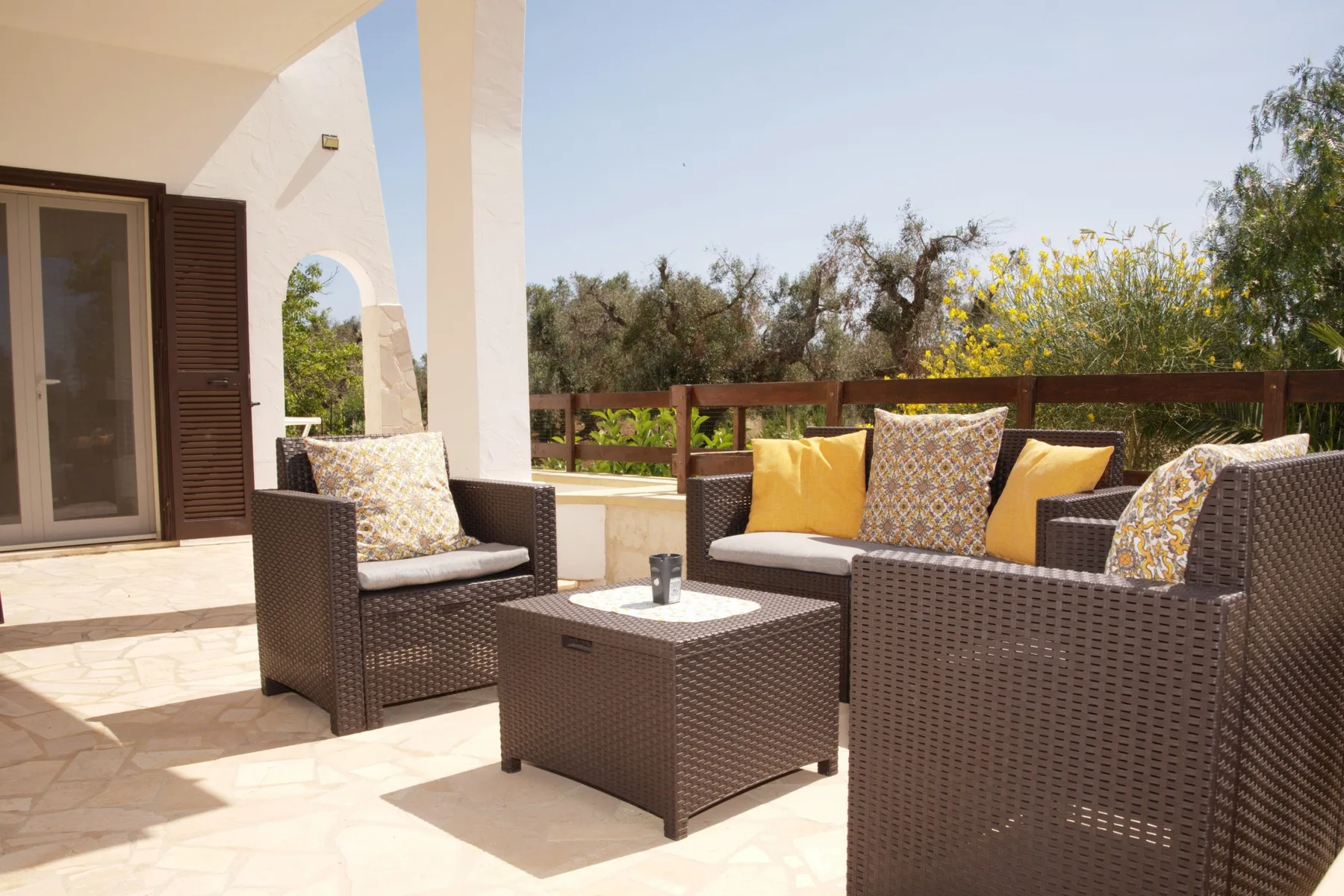 An outdoor patio seating area with cushioned furniture and a low table.