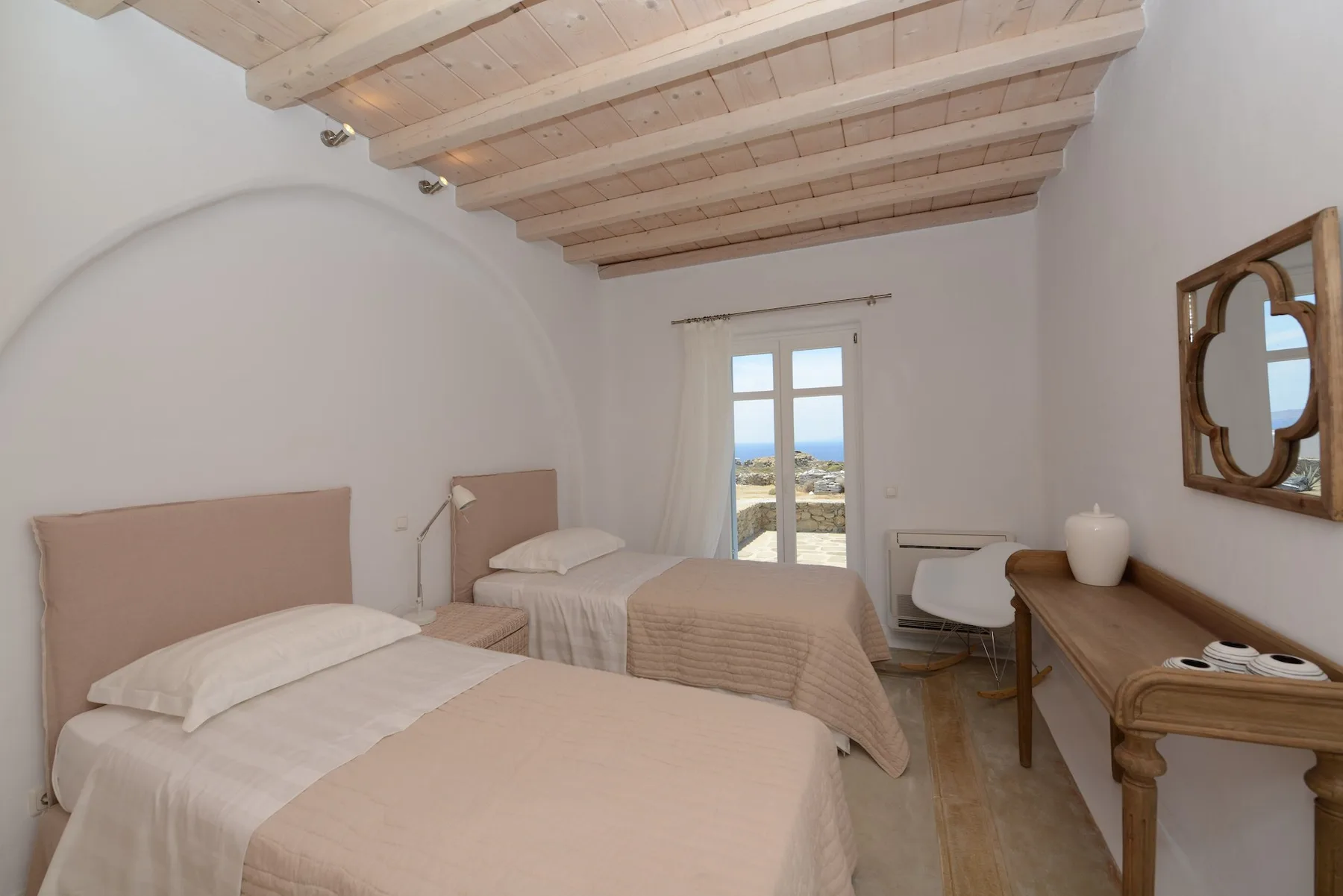 A bedroom with twin beds and a wooden beamed ceiling.