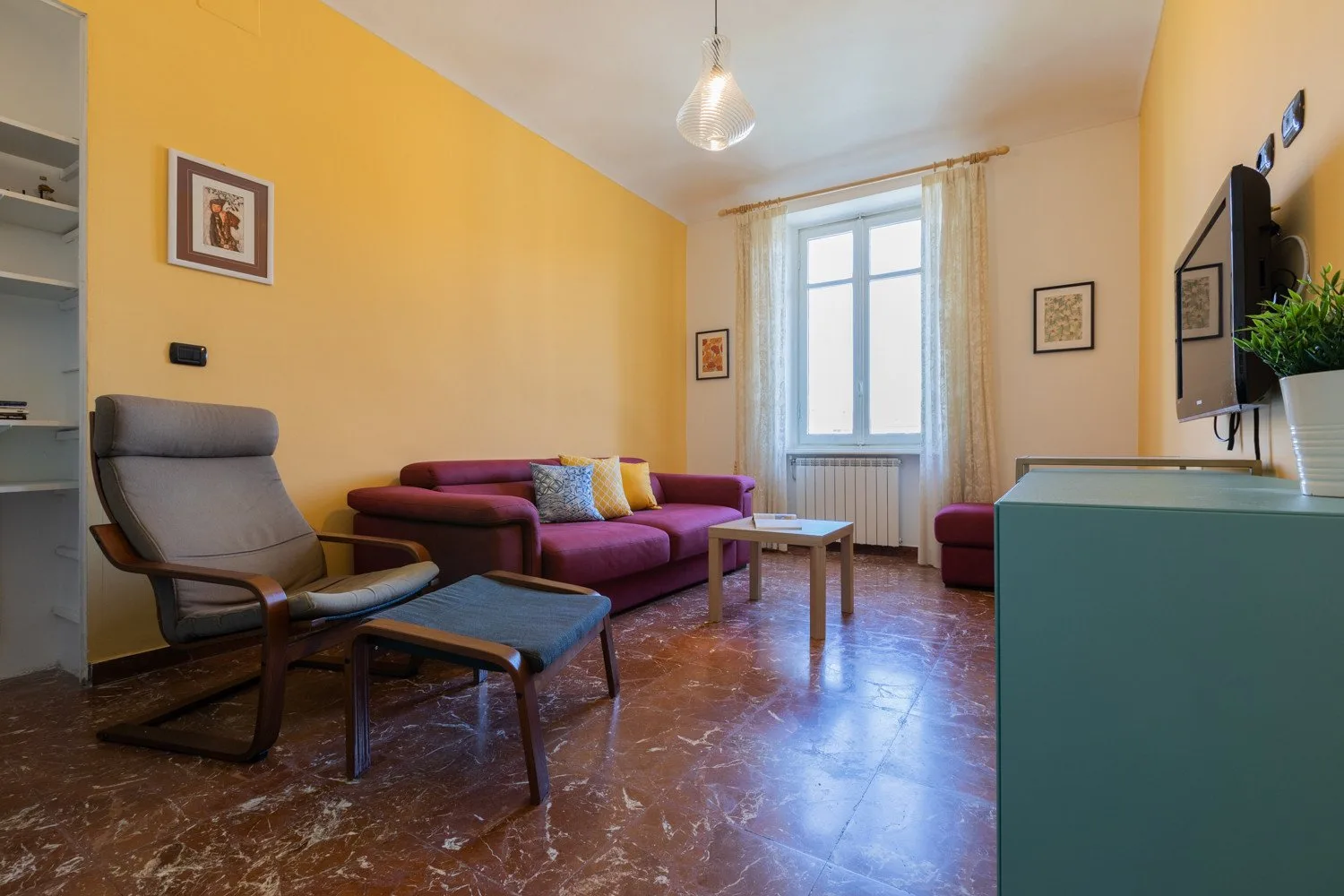 Una sala de estar con asientos alrededor de una mesa de centro junto a una ventana luminosa.