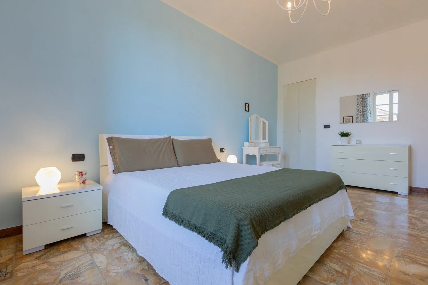 Un dormitorio con una cama grande, mesillas de noche y una cómoda.