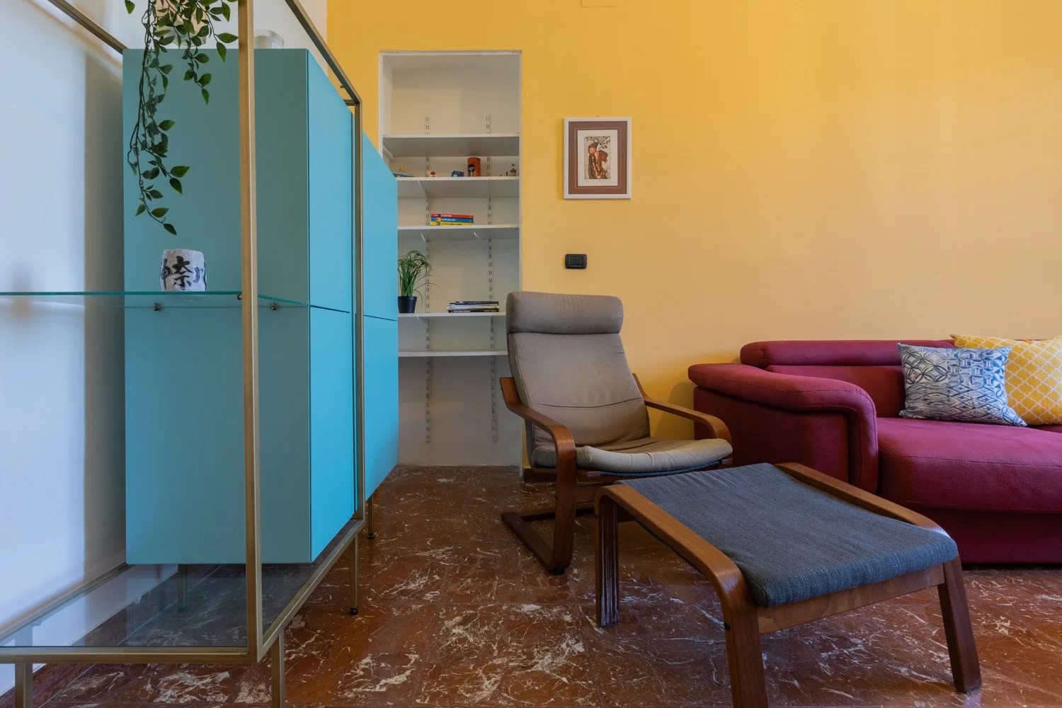Una sala de estar con un sillón, una mesa baja y asientos magenta.