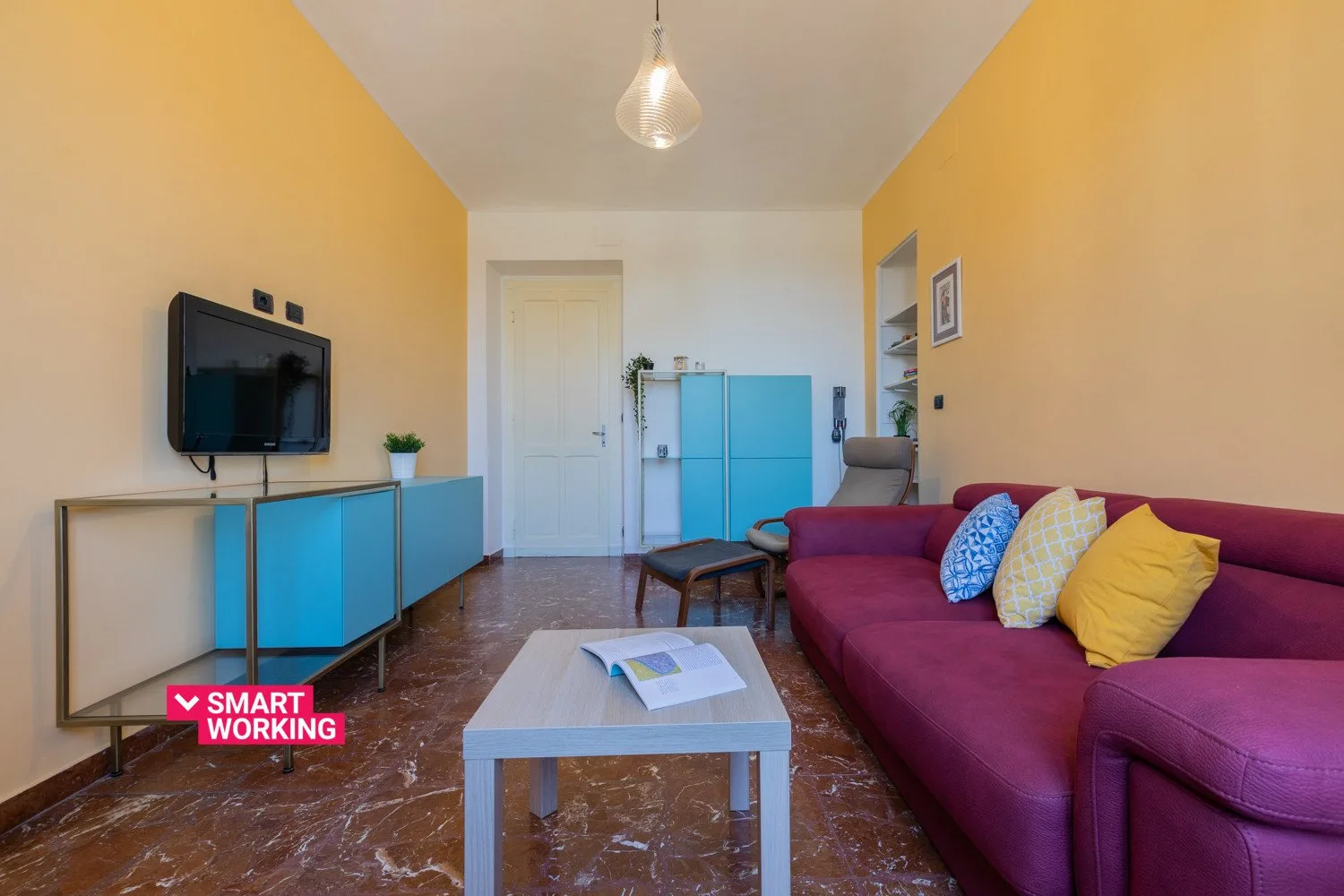 Una sala colorida con sofá, mesa de centro y televisor.