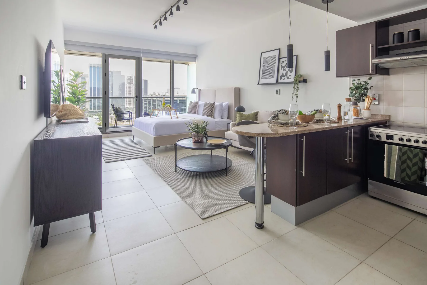 Sala de estar y cocina de concepto abierto, con zona de estar y grandes ventanales.