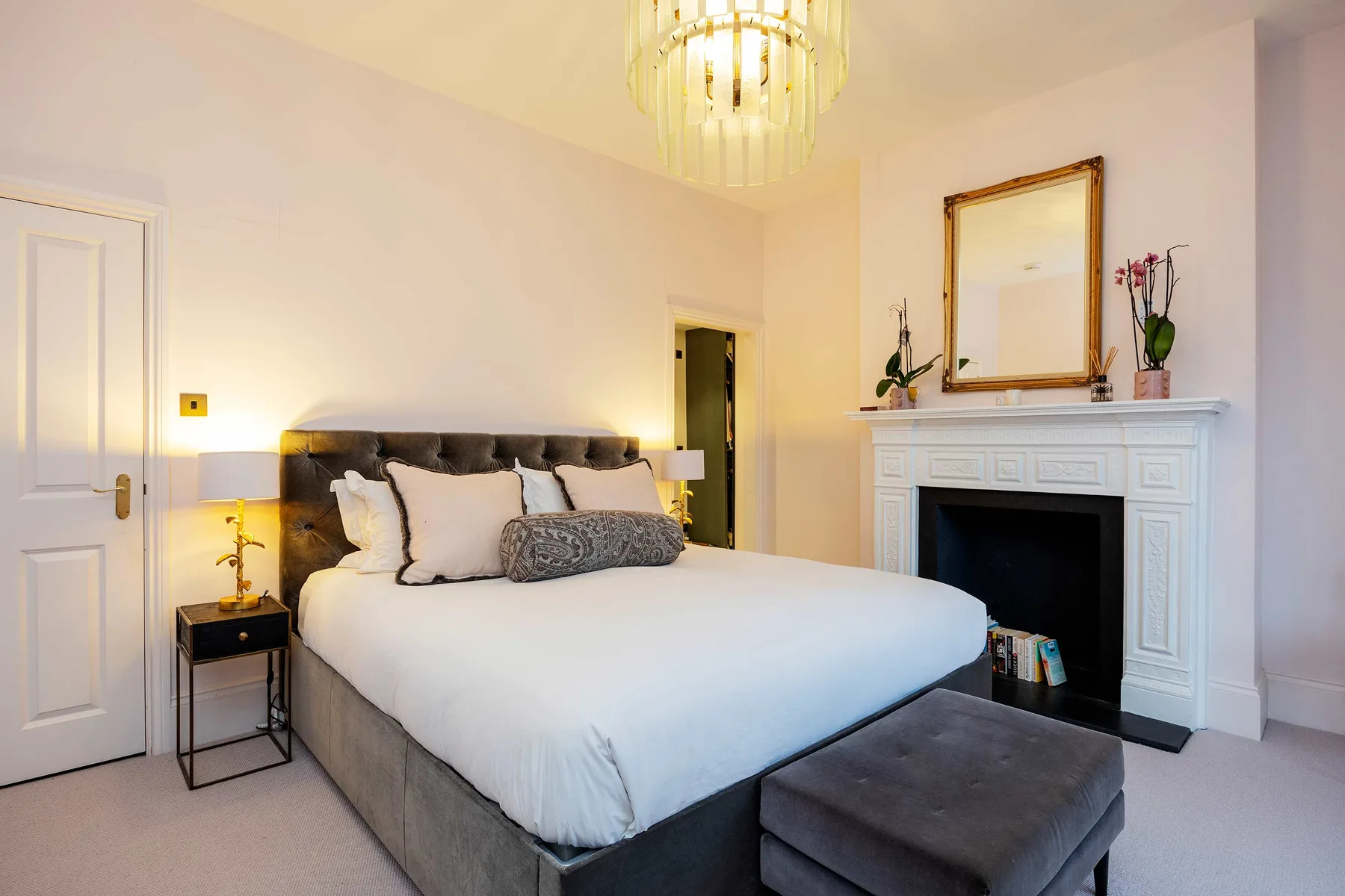A bedroom with a large bed and a fireplace.