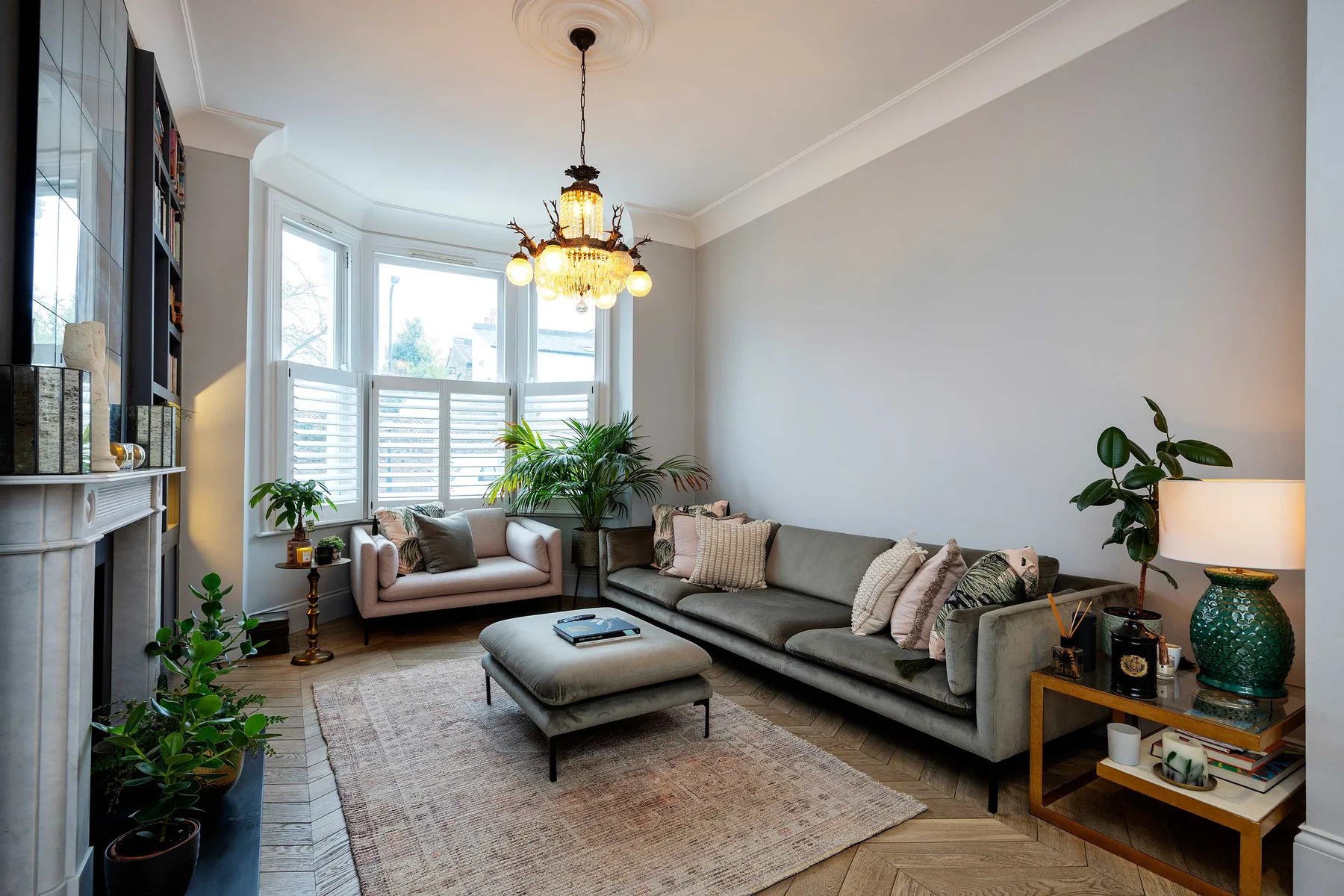 A bright living room with seating arranged around a central ottoman.