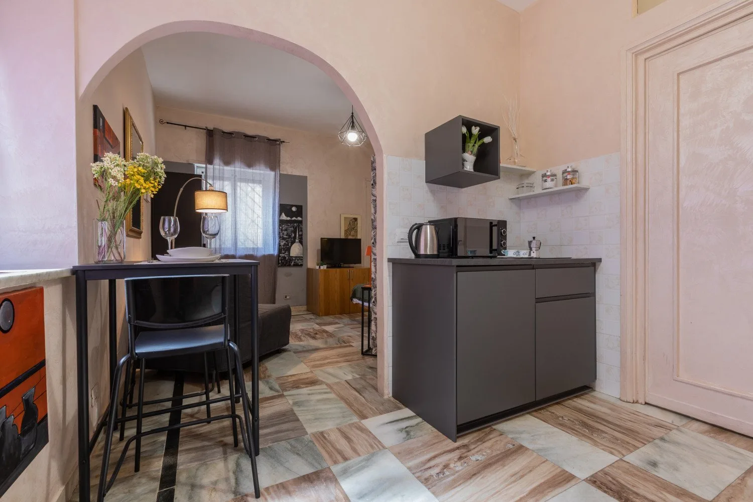 Una cocina compacta se abre, a través de un arco, a una zona de estar y comedor.