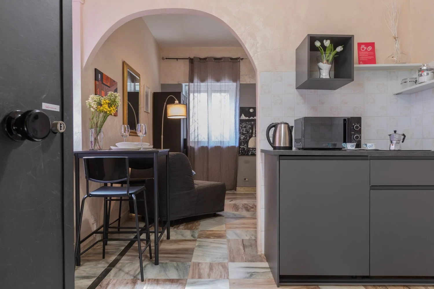 Una cocina compacta se abre a una sala de estar con mesa de comedor y asientos.