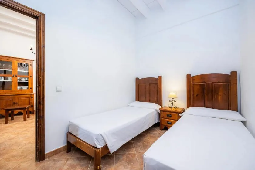 Un dormitorio con dos camas individuales y una pequeña mesita de noche.