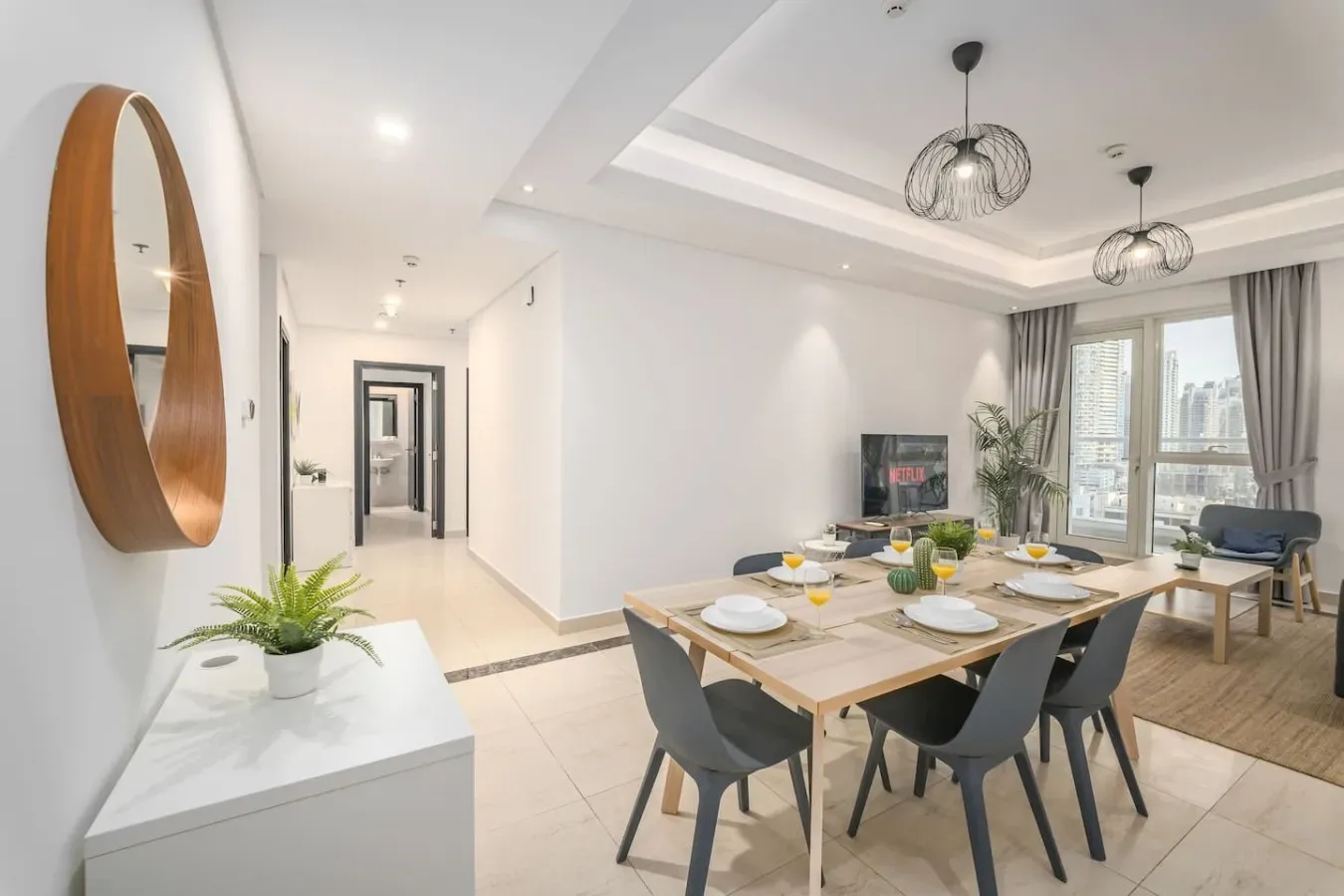 A dining area with a set table beside large windows.