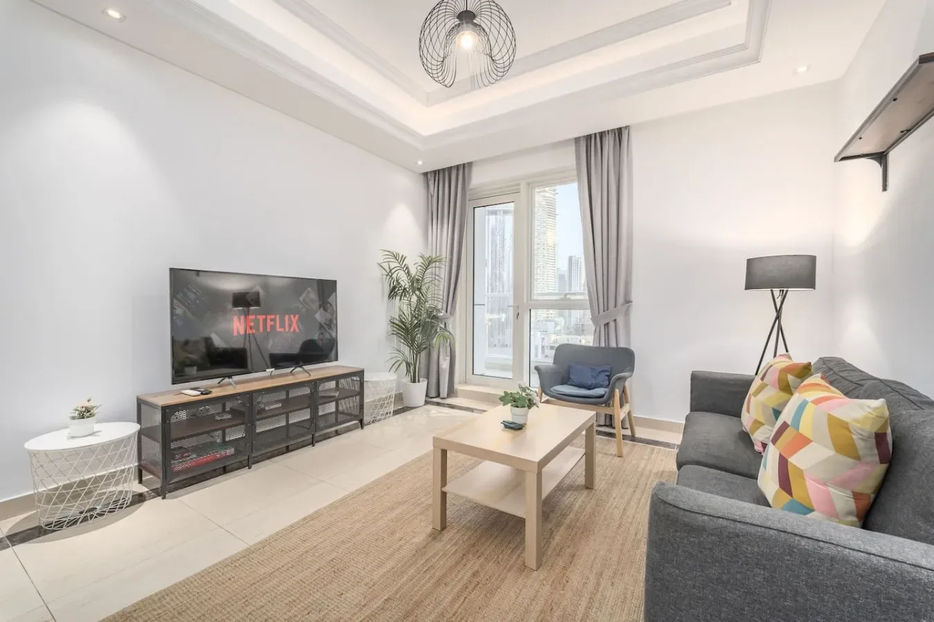Una sala luminosa con asientos, una mesa de centro y un televisor.