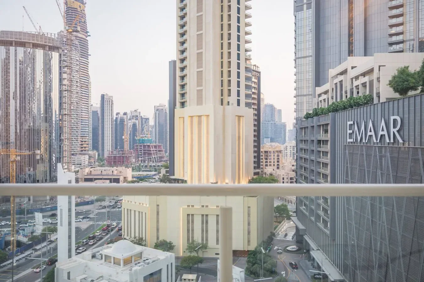 Vista del horizonte urbano desde un balcón, con una torre alta en primer plano.