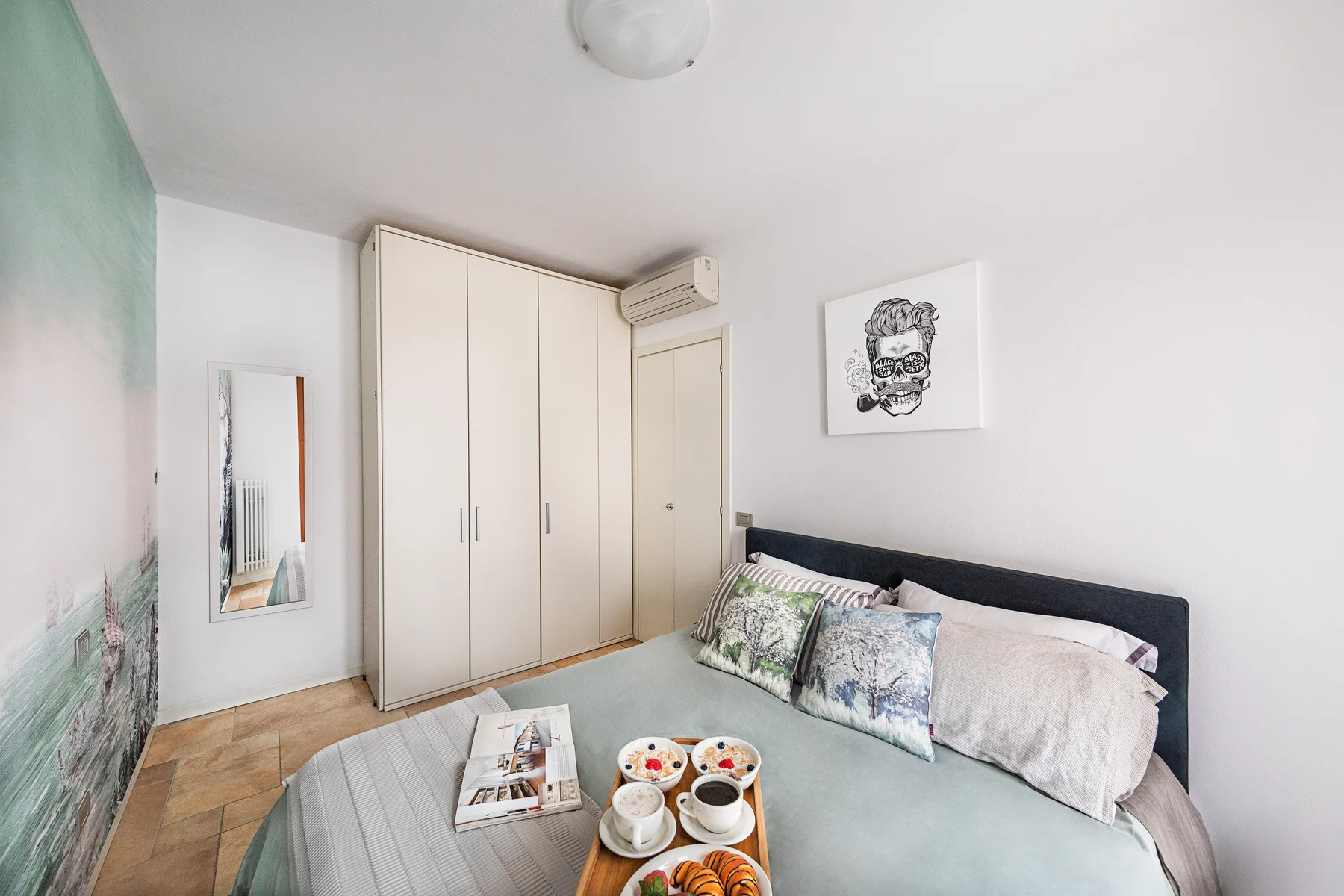 A bedroom with a bed, pillows, and a wardrobe.
