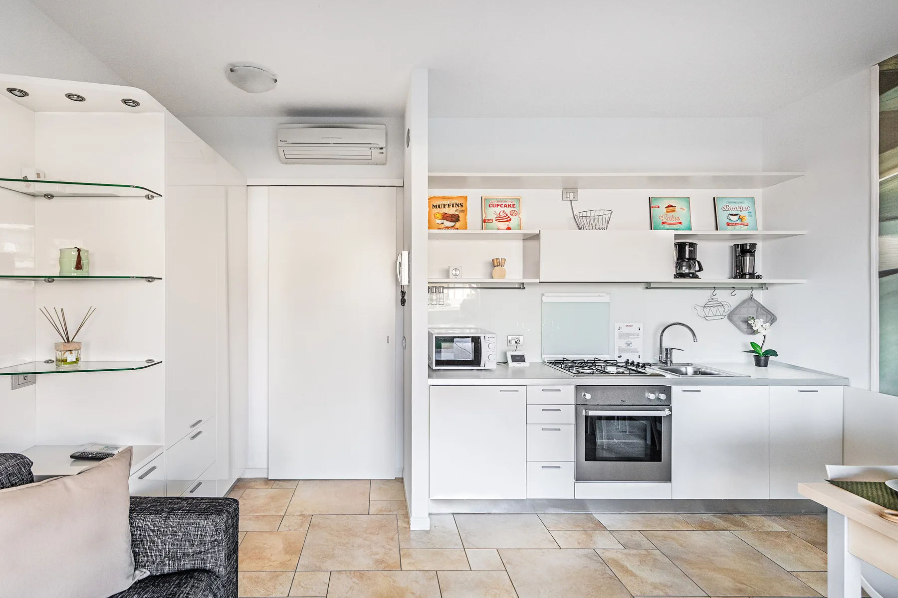 A bright kitchen with white cabinets, a countertop, and built-in appliances.