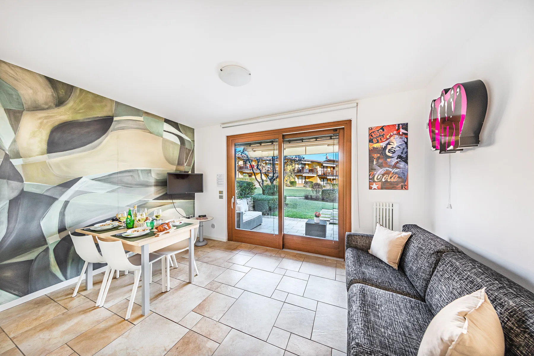 A bright living area with a dining table and sliding glass doors opening onto a patio.