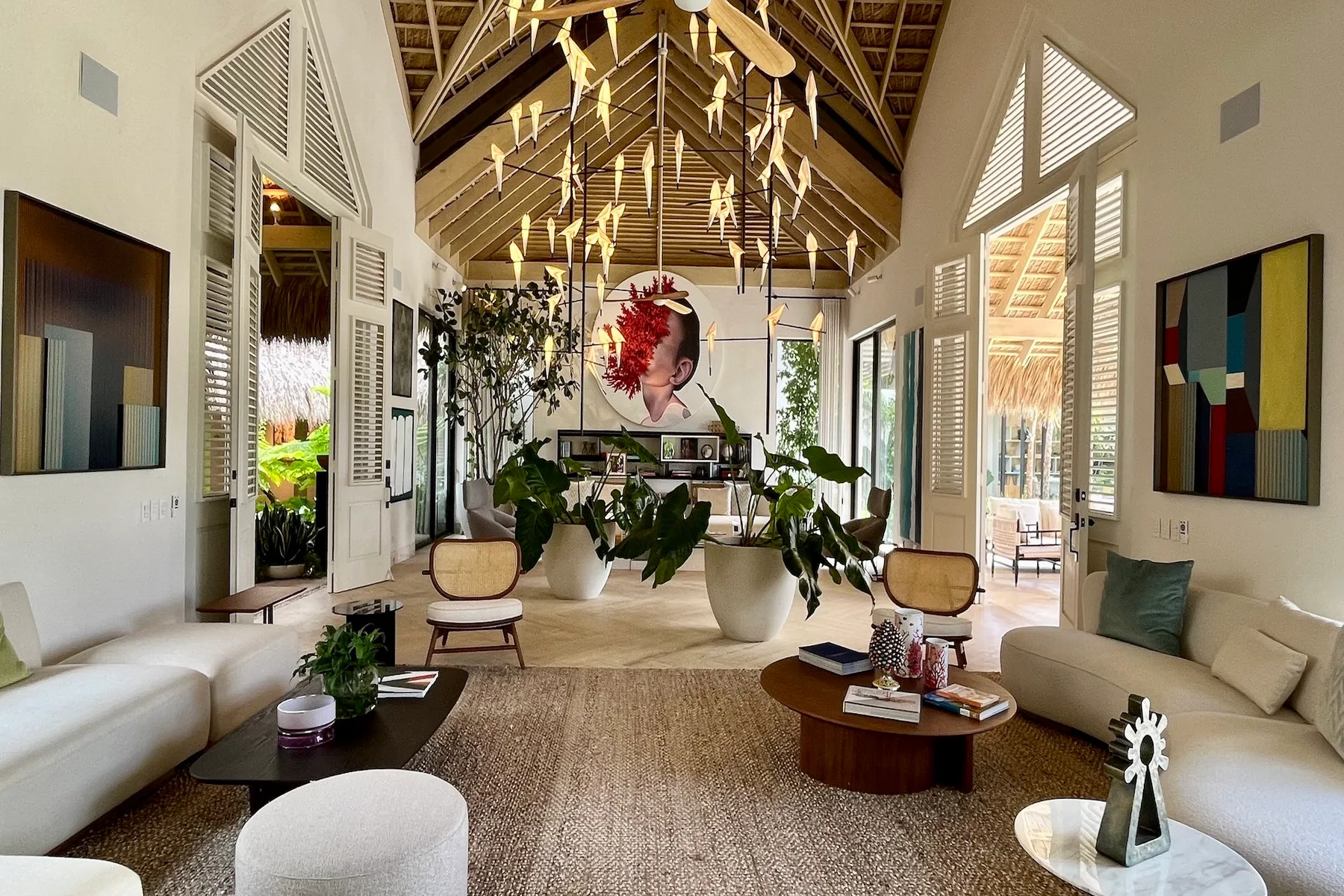Una sala luminosa con asientos, plantas y un techo alto de madera.