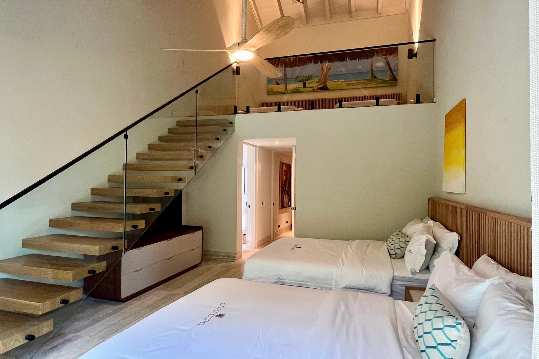 Un dormitorio con dos camas y una escalera abierta junto a una pared.
