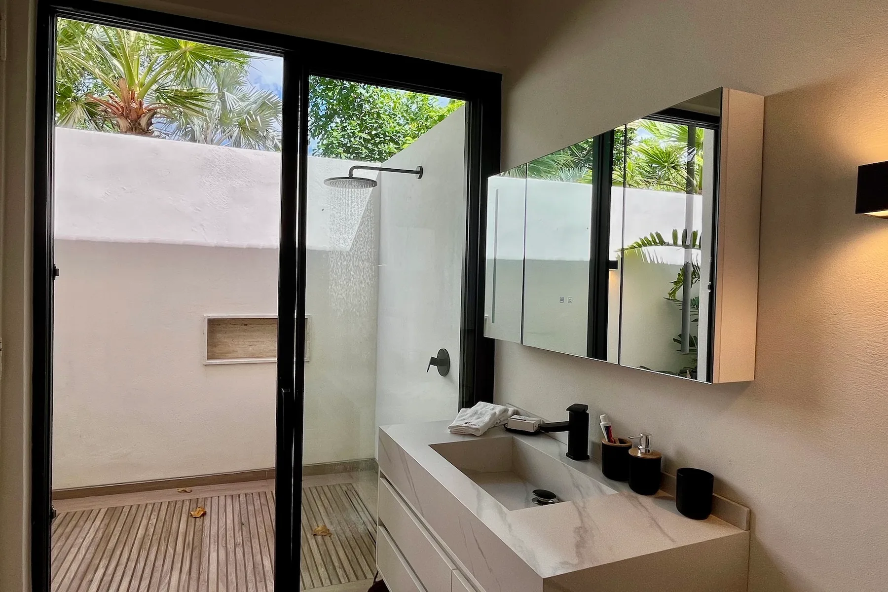 Un baño moderno con un lavabo blanco y una ducha acristalada.