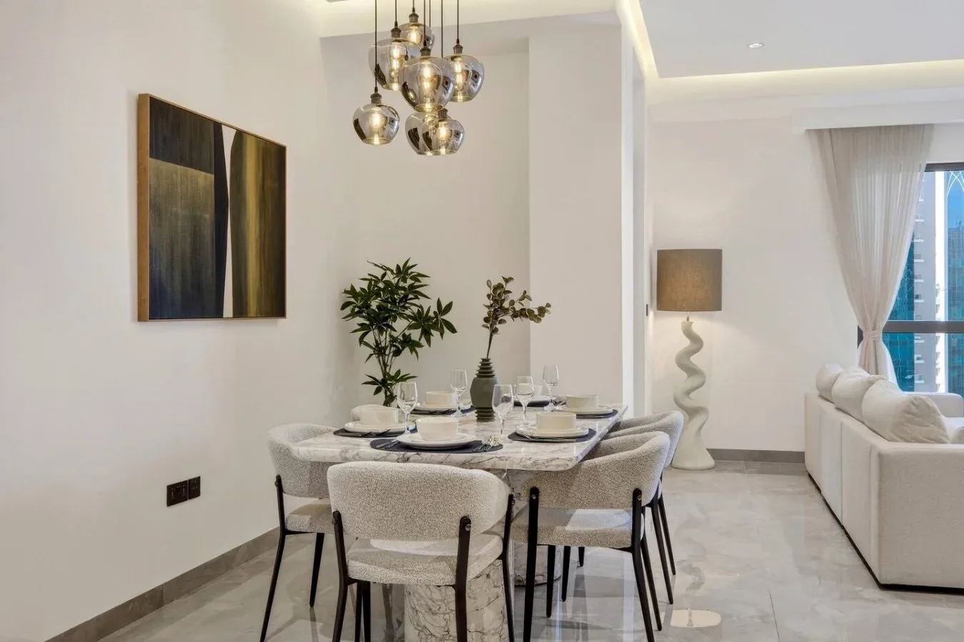 A dining area with a set table beside a bright living room.