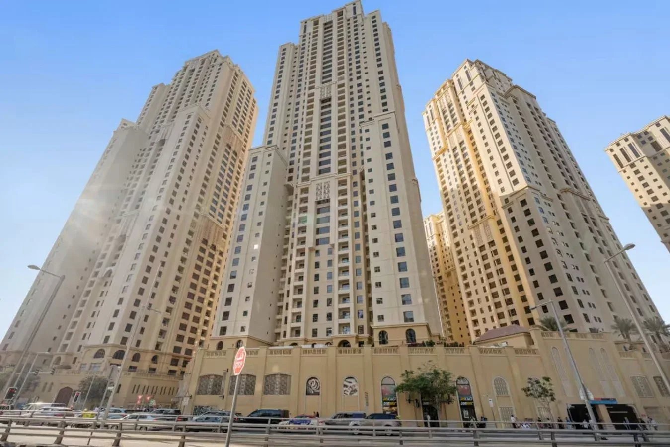 Tall residential towers rise above a street lined with storefronts.