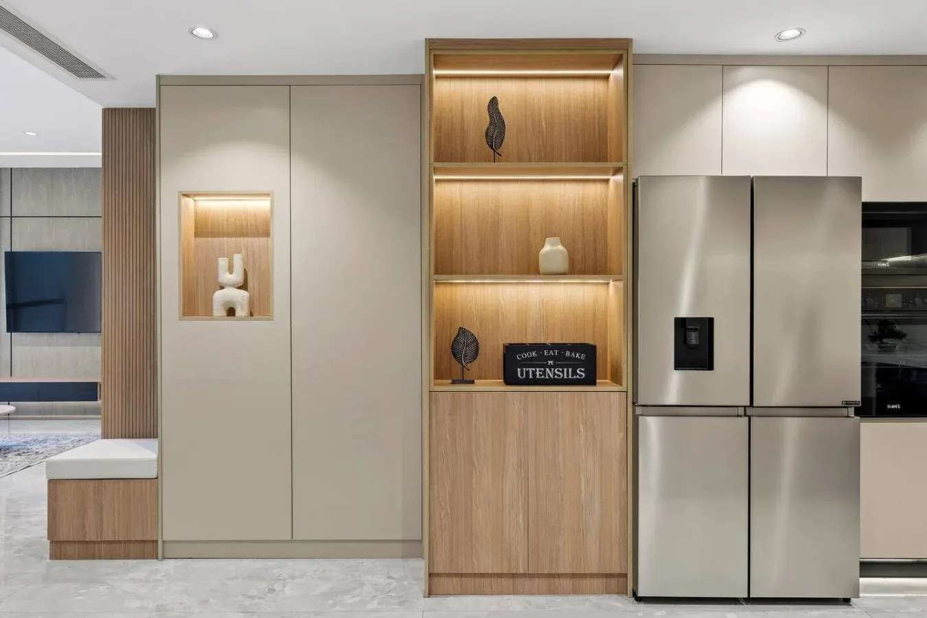 A modern kitchen with illuminated wooden display shelves and stainless steel appliances.