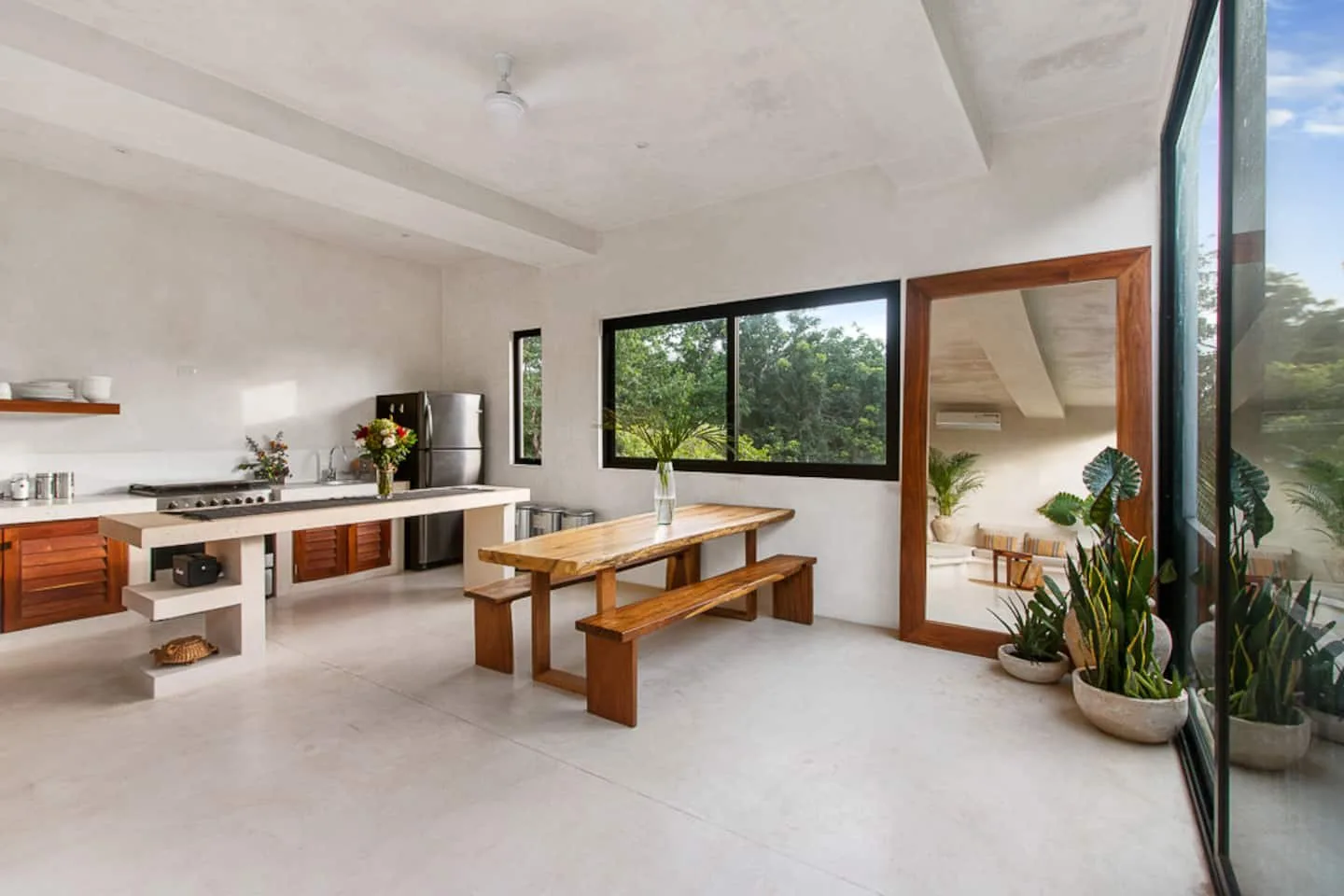 Un comedor amplio y luminoso con una mesa de madera junto a la cocina.