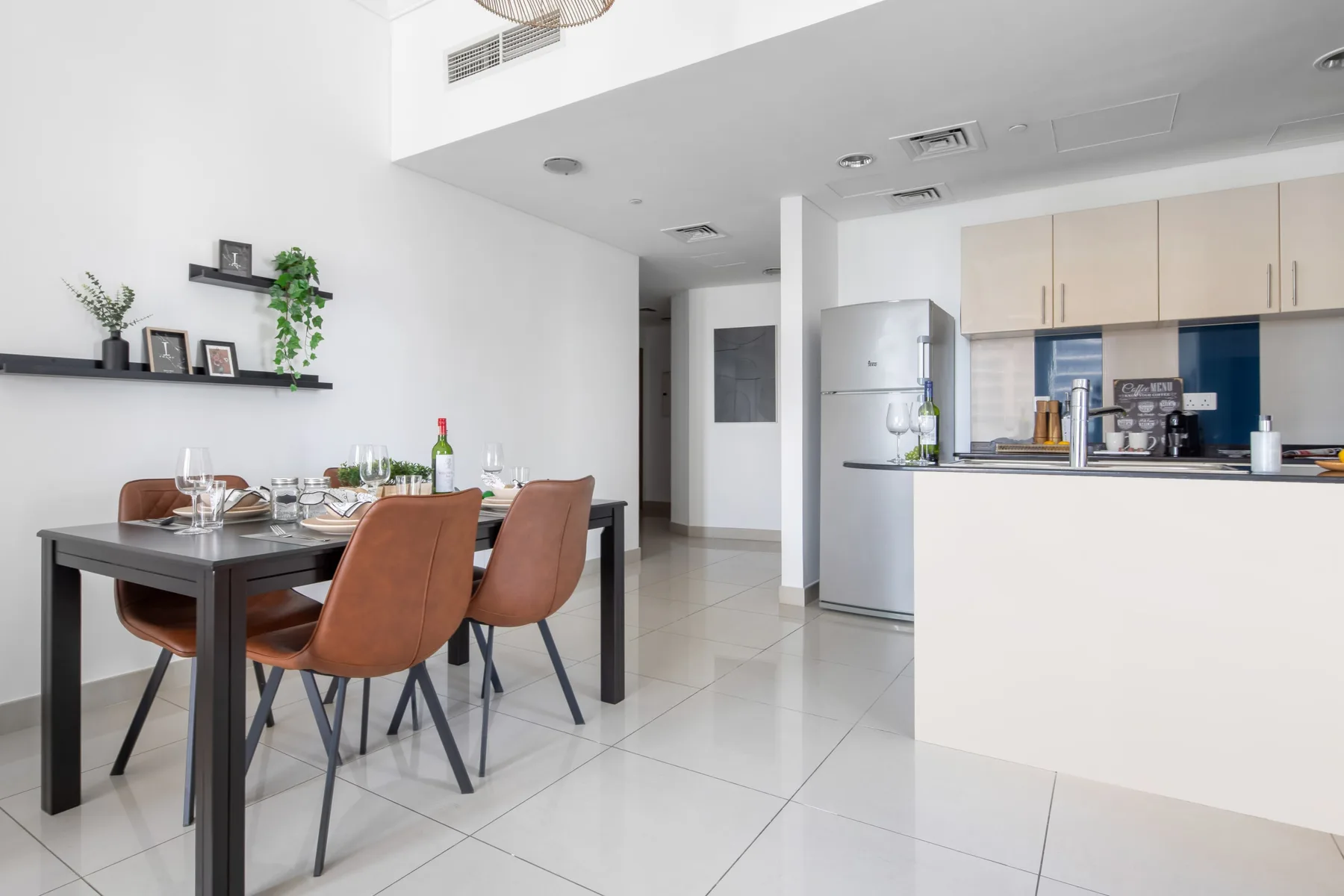 Comedor junto a una cocina abierta, con la mesa puesta y una encimera.