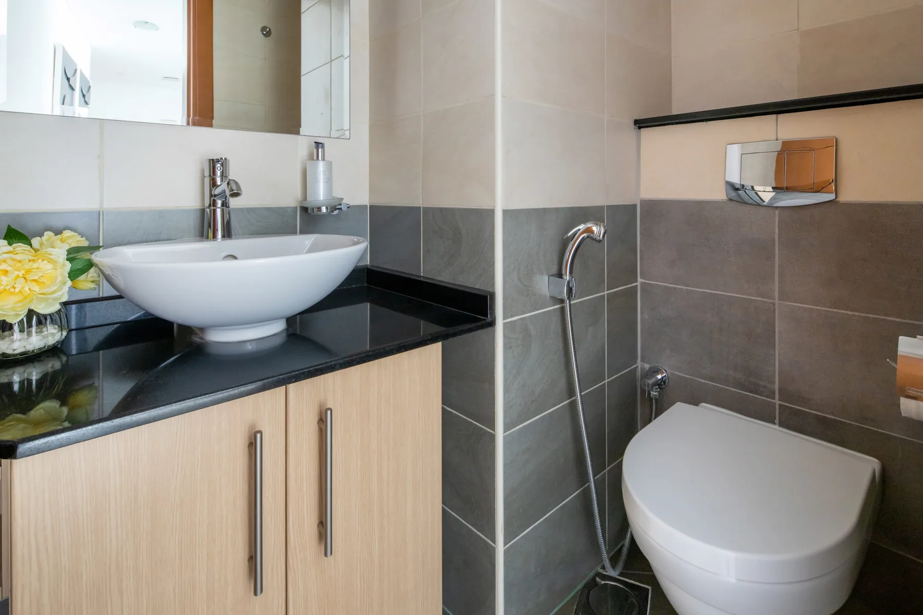 Un baño con lavabo e inodoro junto a paredes de azulejos.