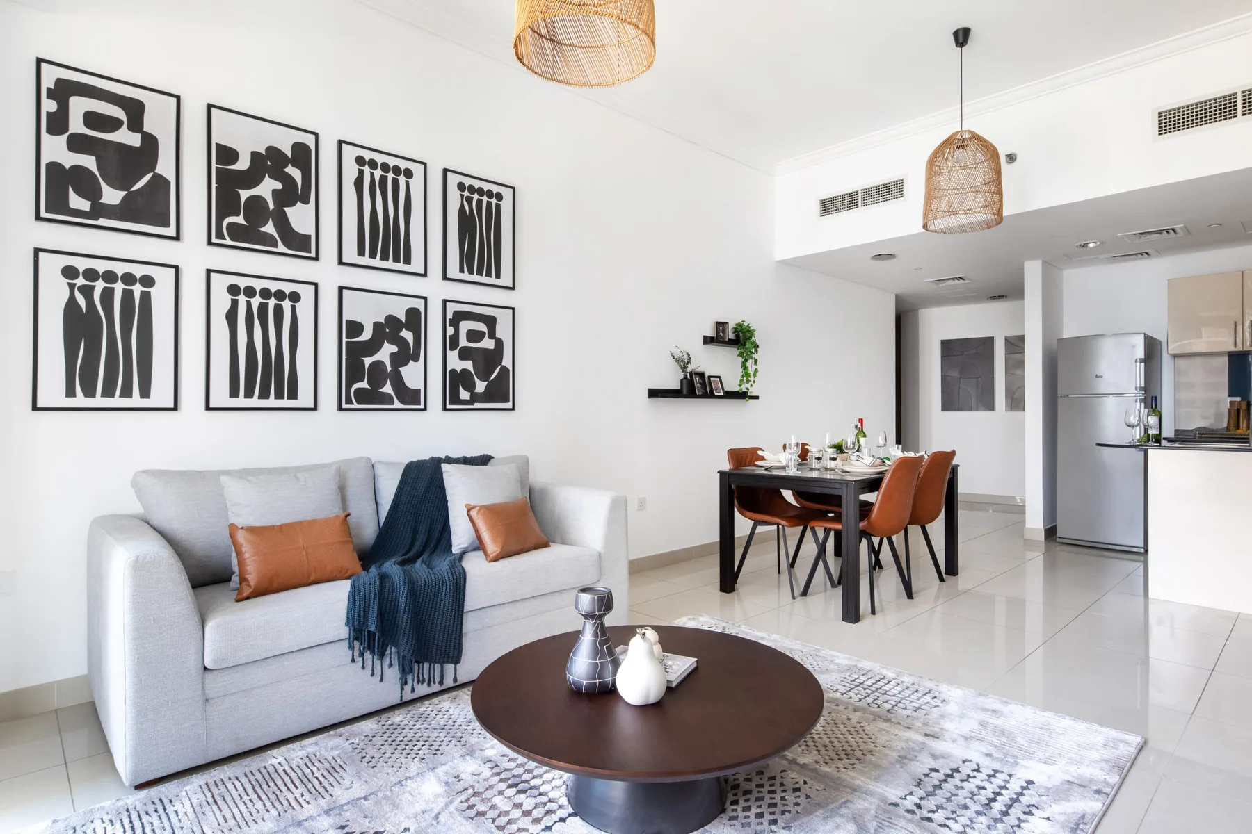 Sala de estar con sofá y mesa de comedor en un espacio diáfano.
