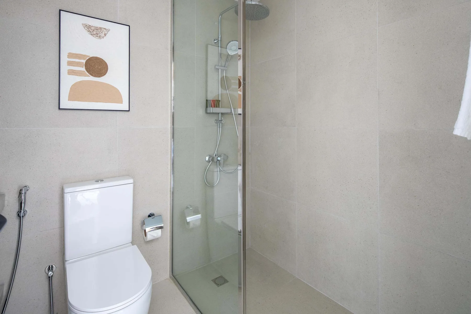 Un baño moderno con ducha de vidrio e inodoro.