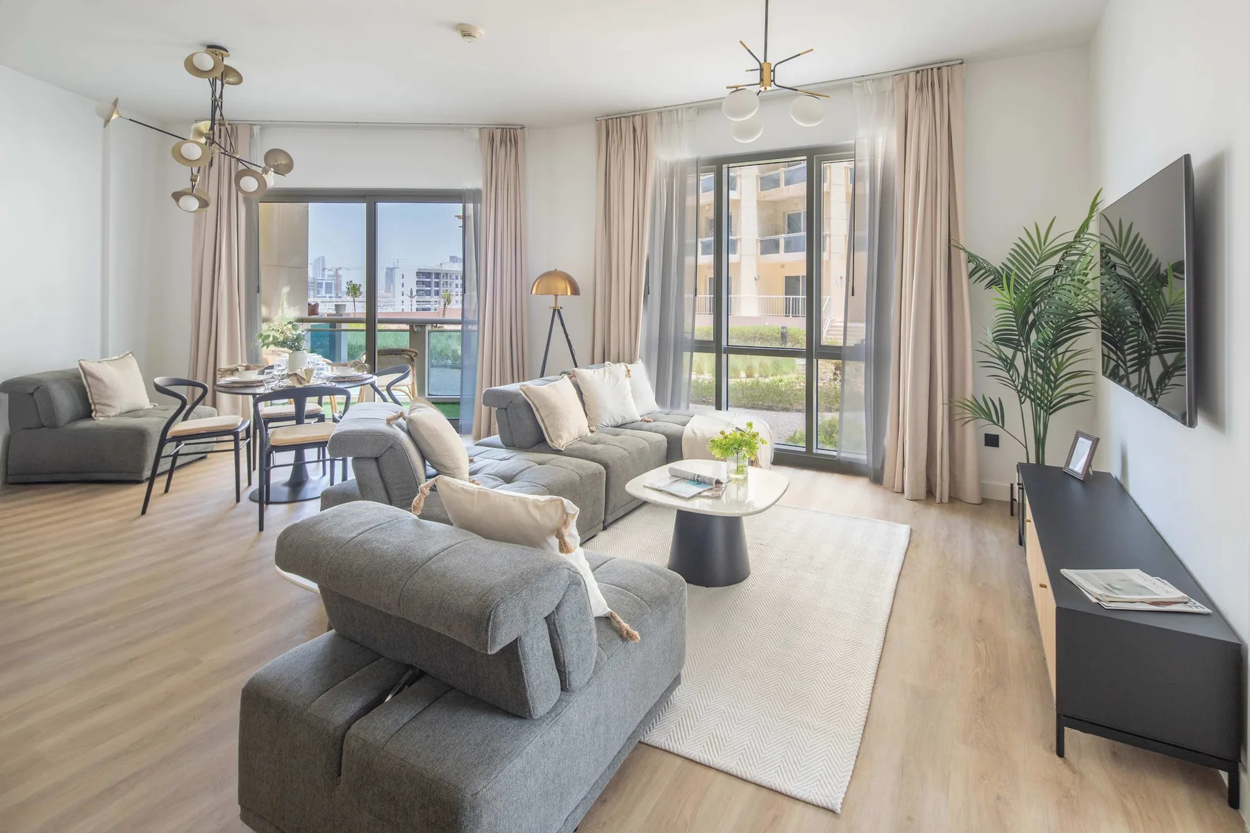 A bright living room with seating, a coffee table, and large windows.