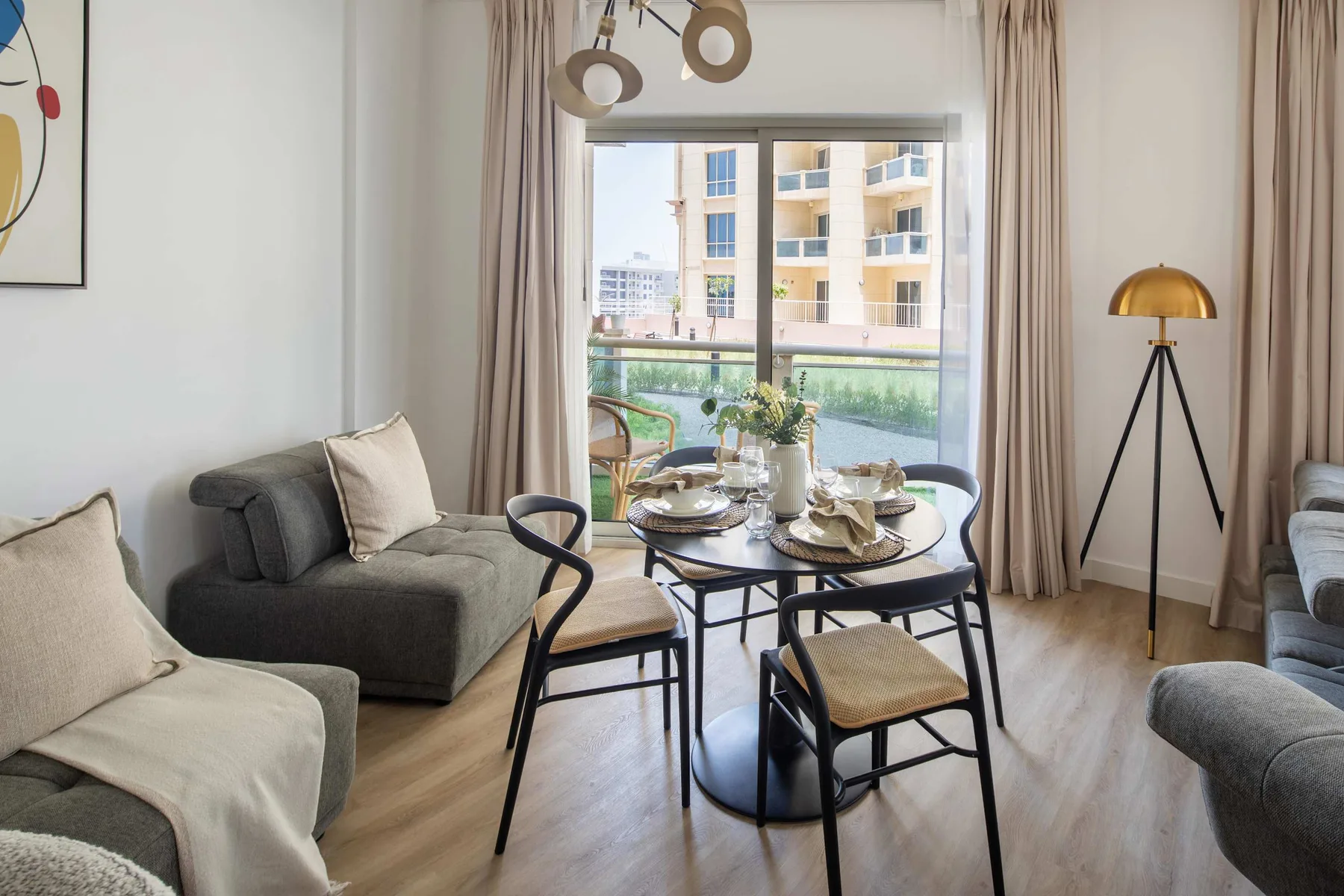 Una sala de estar con asientos y una mesa de comedor junto a una ventana grande.