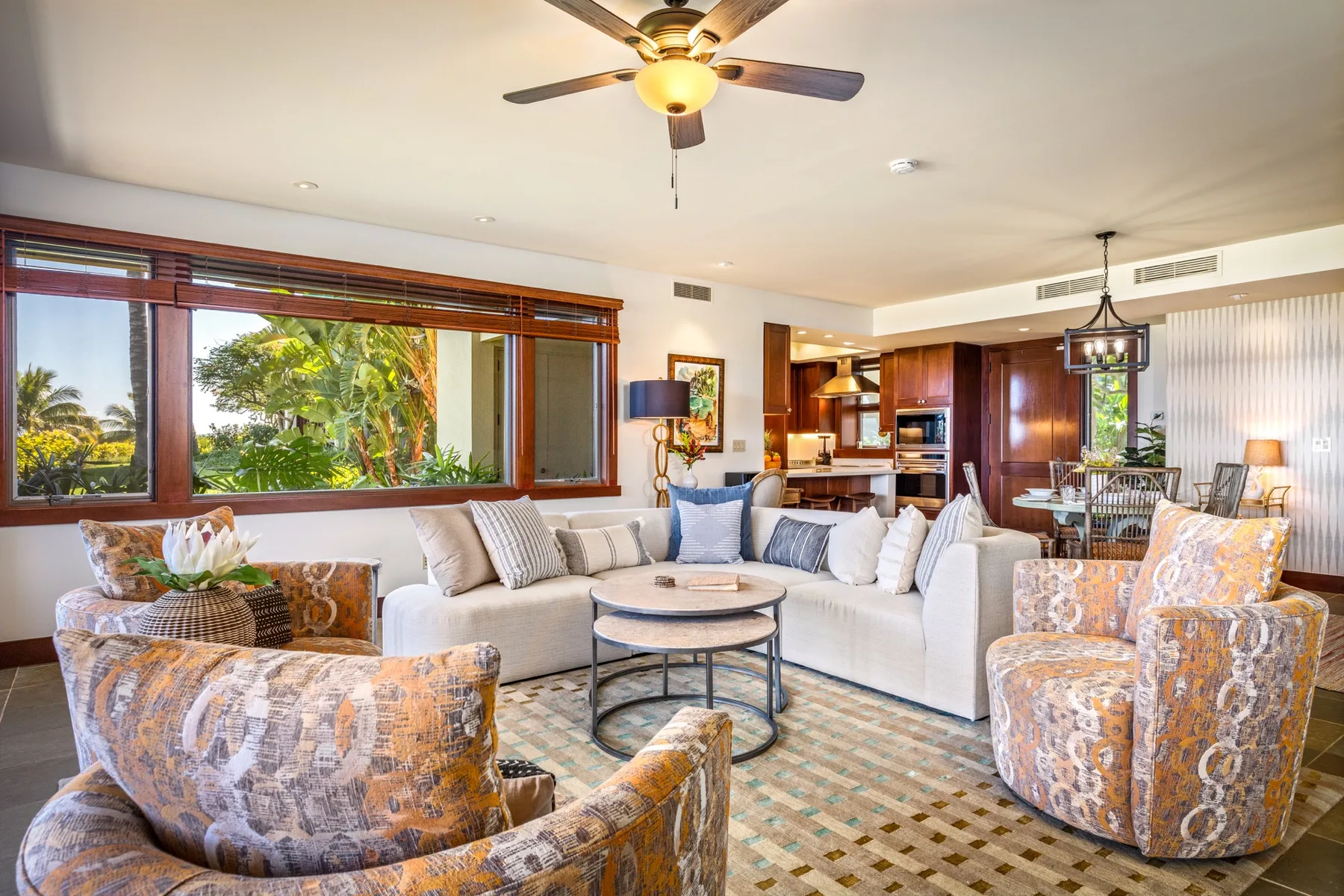 A bright living room with seating arranged around a round coffee table.