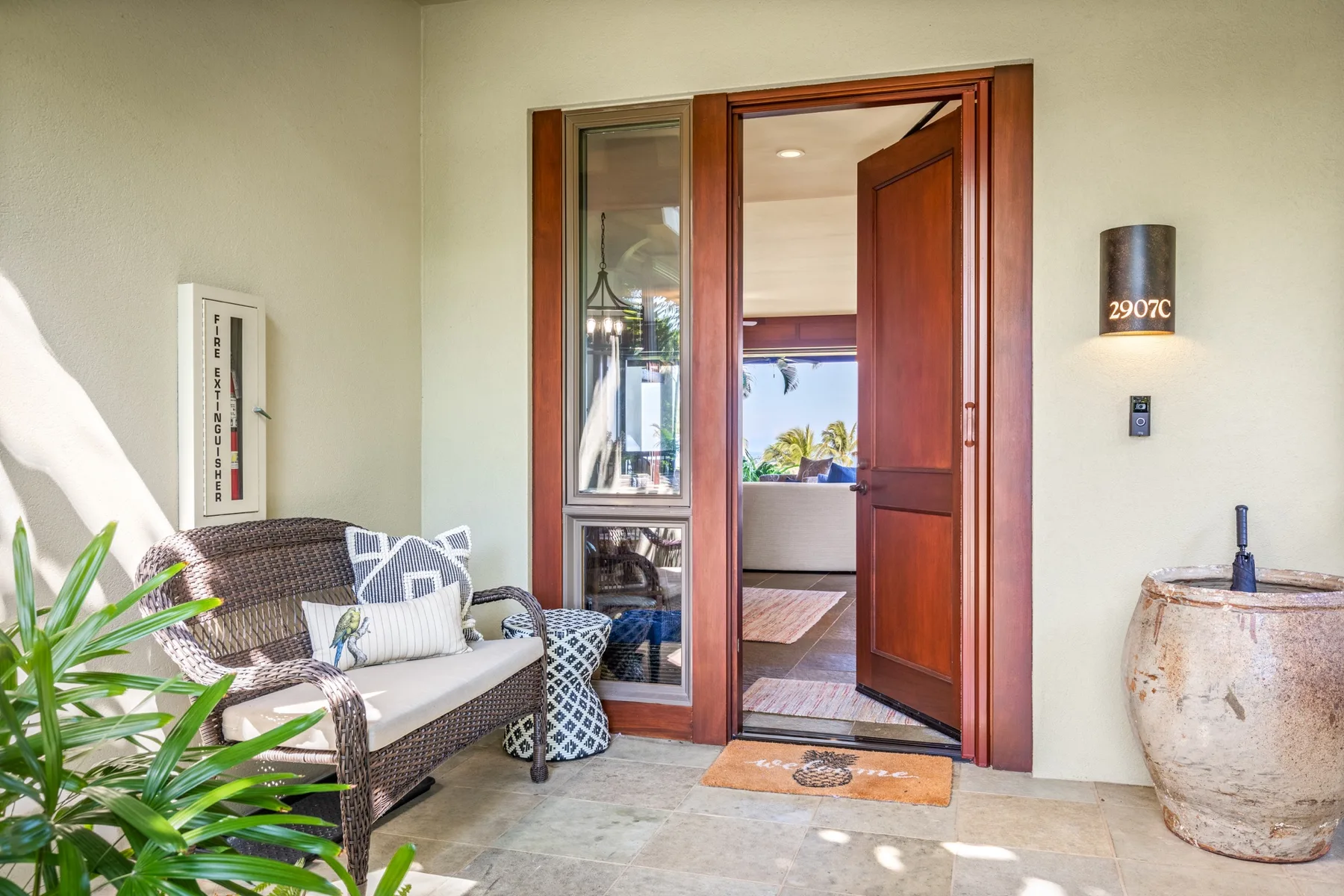 A seating area beside a wooden doorway opens onto a bright interior room.