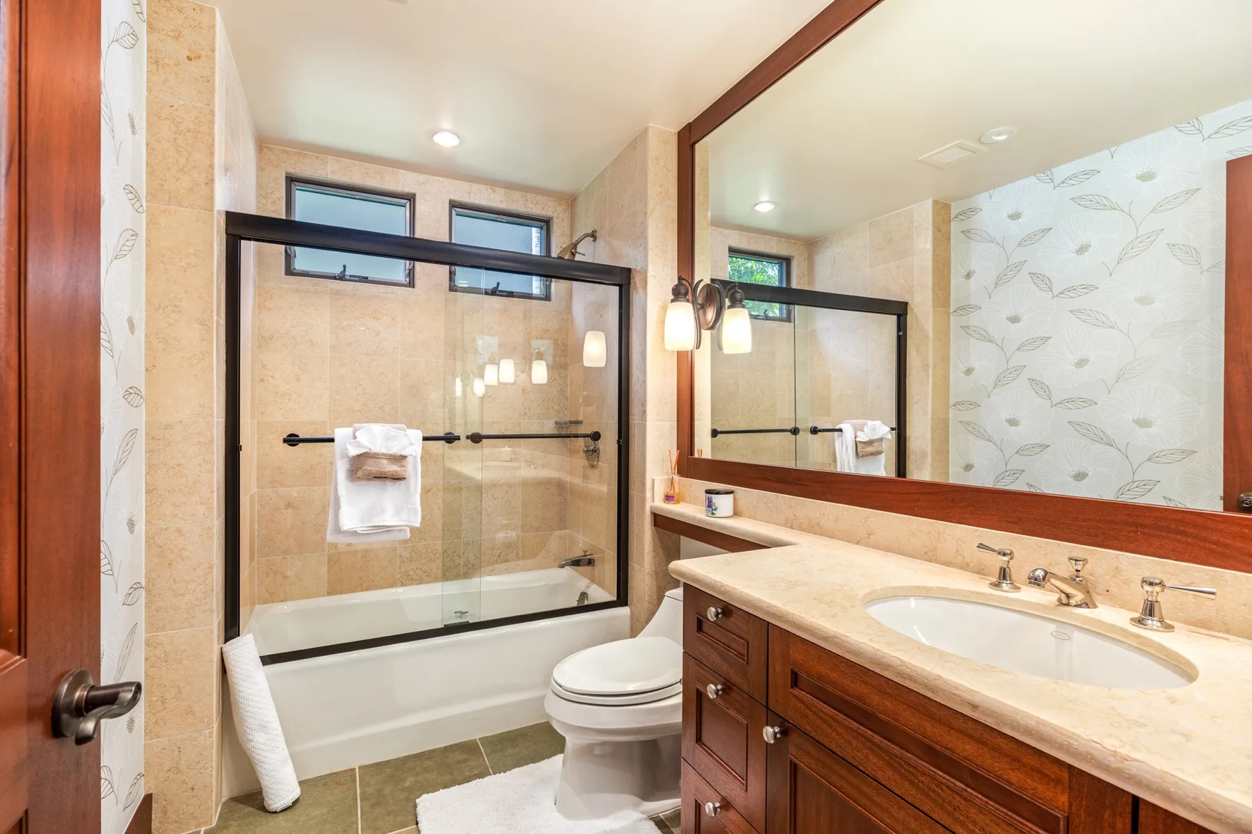 A bathroom with a bathtub, shower, toilet, and long vanity.