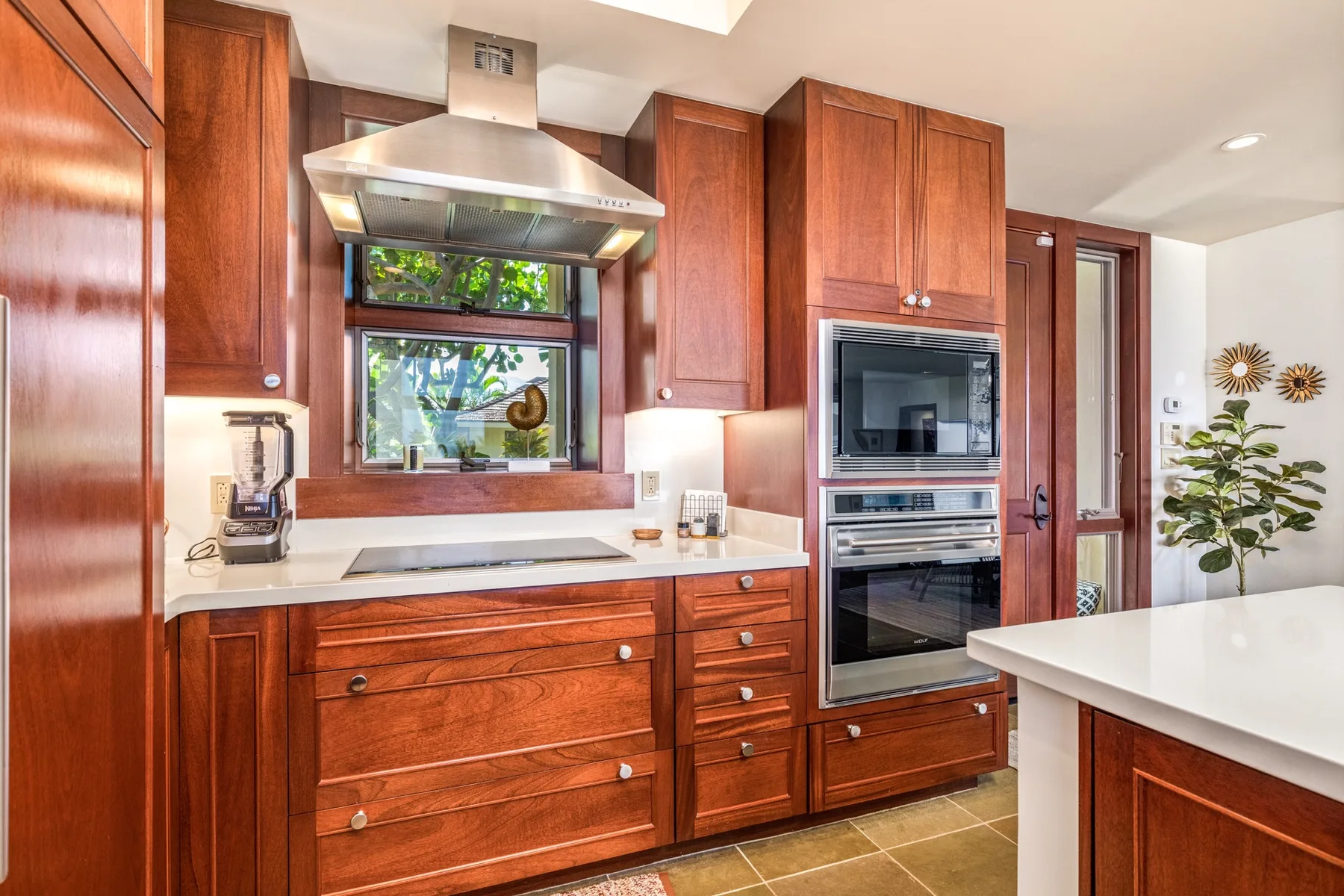 A kitchen with wooden cabinets, a countertop, and built-in appliances.