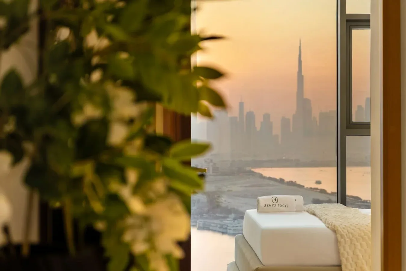 Una ventana del dormitorio enmarca un horizonte urbano brumoso sobre el agua.