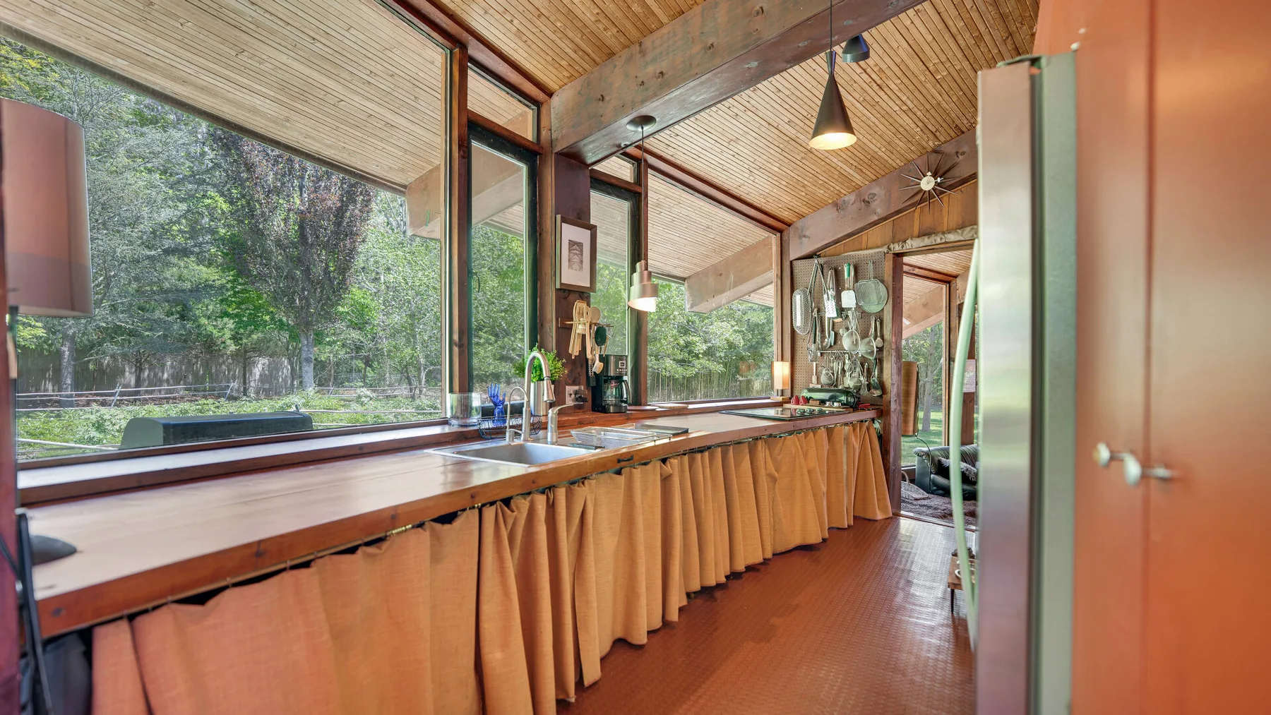 Un mostrador largo recorre un salón con paneles de madera y grandes ventanas.