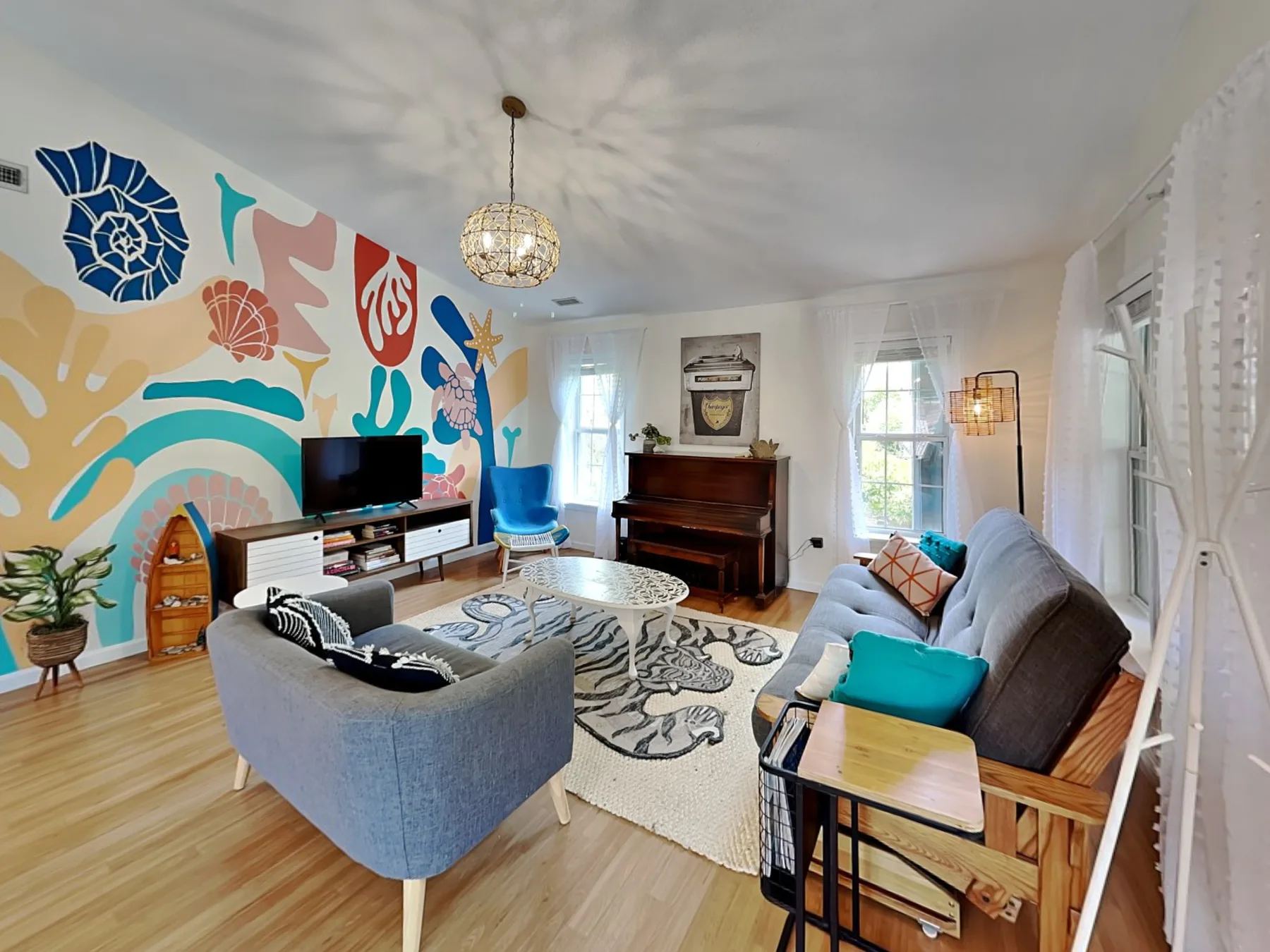 Una sala colorida con asientos, un televisor y un piano.