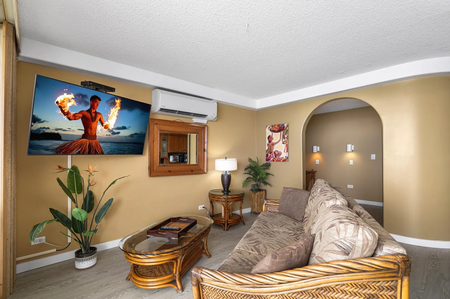 Una sala de estar con televisor, asientos y una mesa de centro baja.