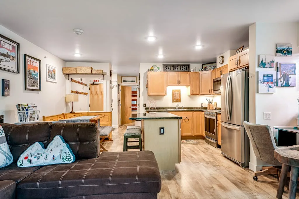 Una sala de estar y cocina de concepto abierto, con una isla central y asientos.