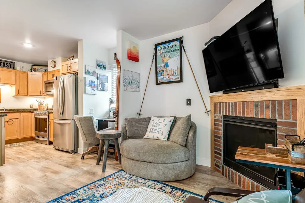 A living area with seating and a television beside a brick fireplace.