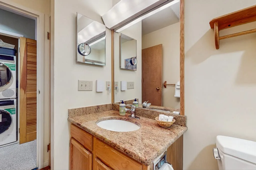 Un lavabo de baño con espejo junto a una puerta.