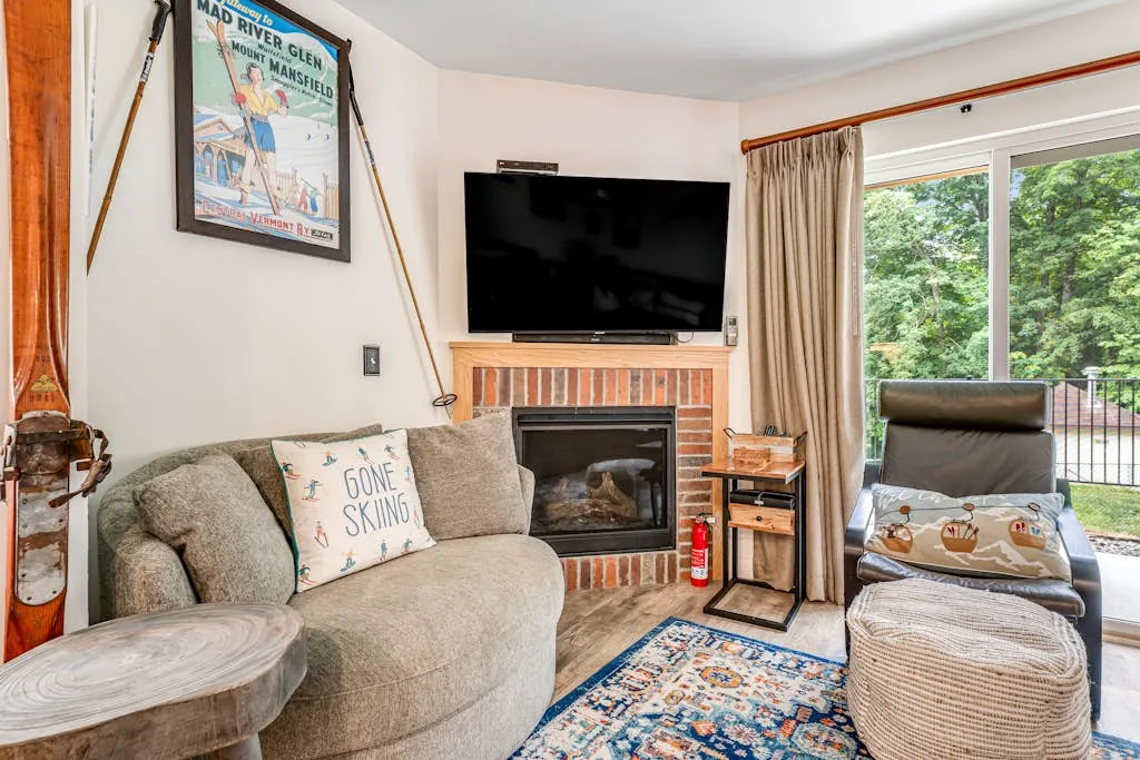 A living room with seating, a fireplace, and a television.