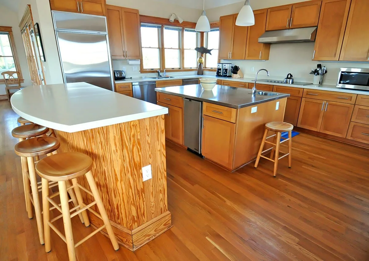 Una cocina amplia con gabinetes de madera, encimeras y una isla central.